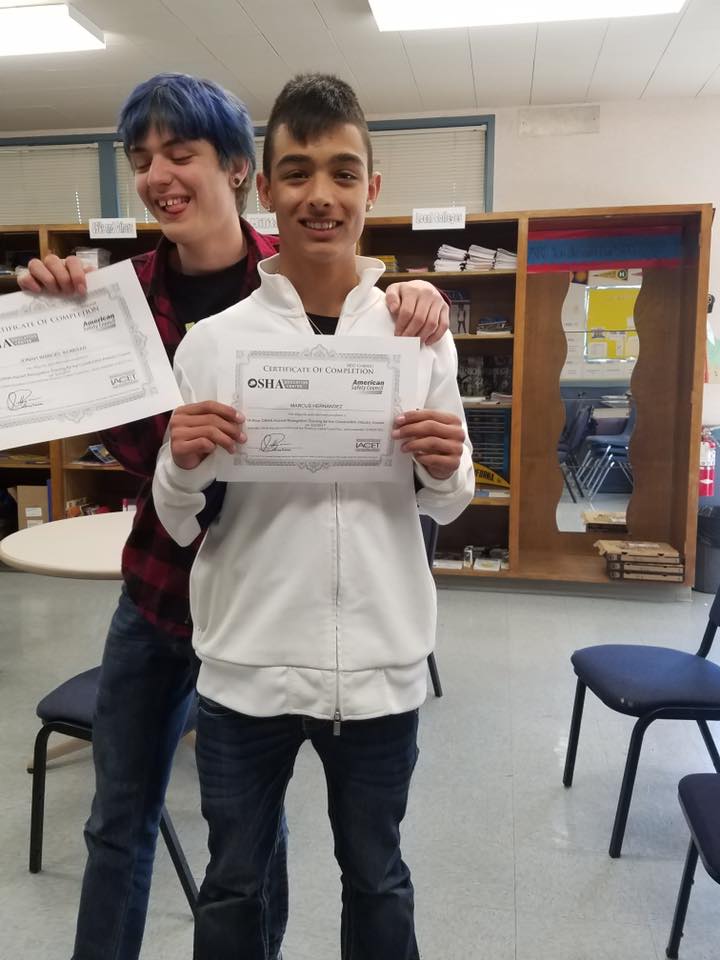 Two boys proudly display their certificates in a classroom at The LIME Foundation of Santa Rosa.