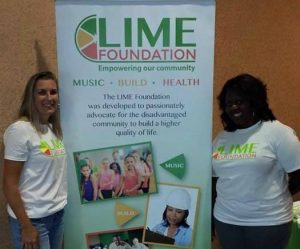 Two women standing in front of the LIME Foundation banner.