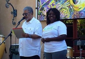 A man and woman standing next to a microphone at a Santa Rosa non-profit event.