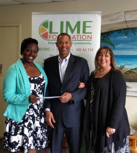 Three people standing in front of a LIME Foundation sign.