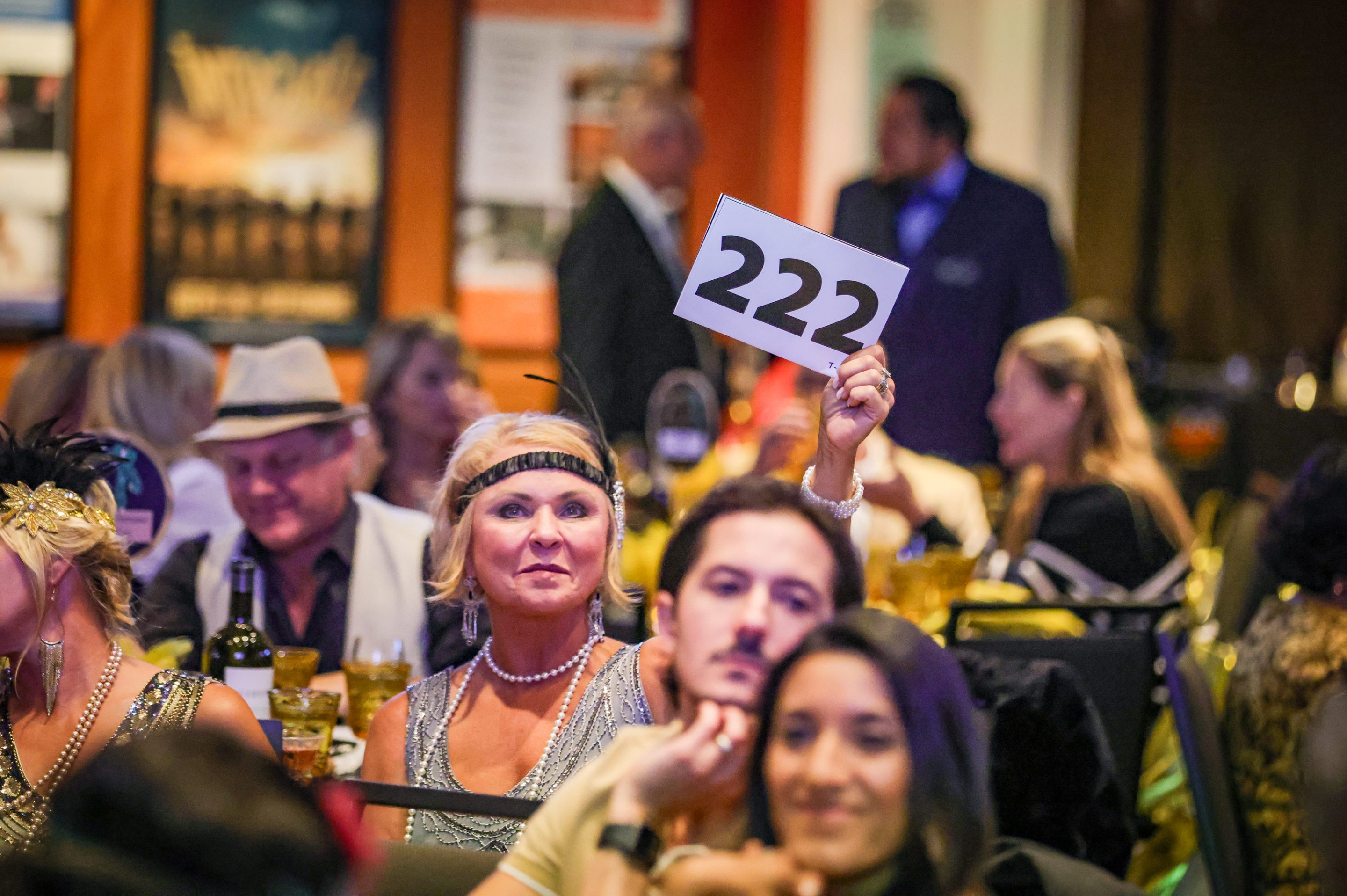 A group of people from a non-profit organization holding up a number at an event.