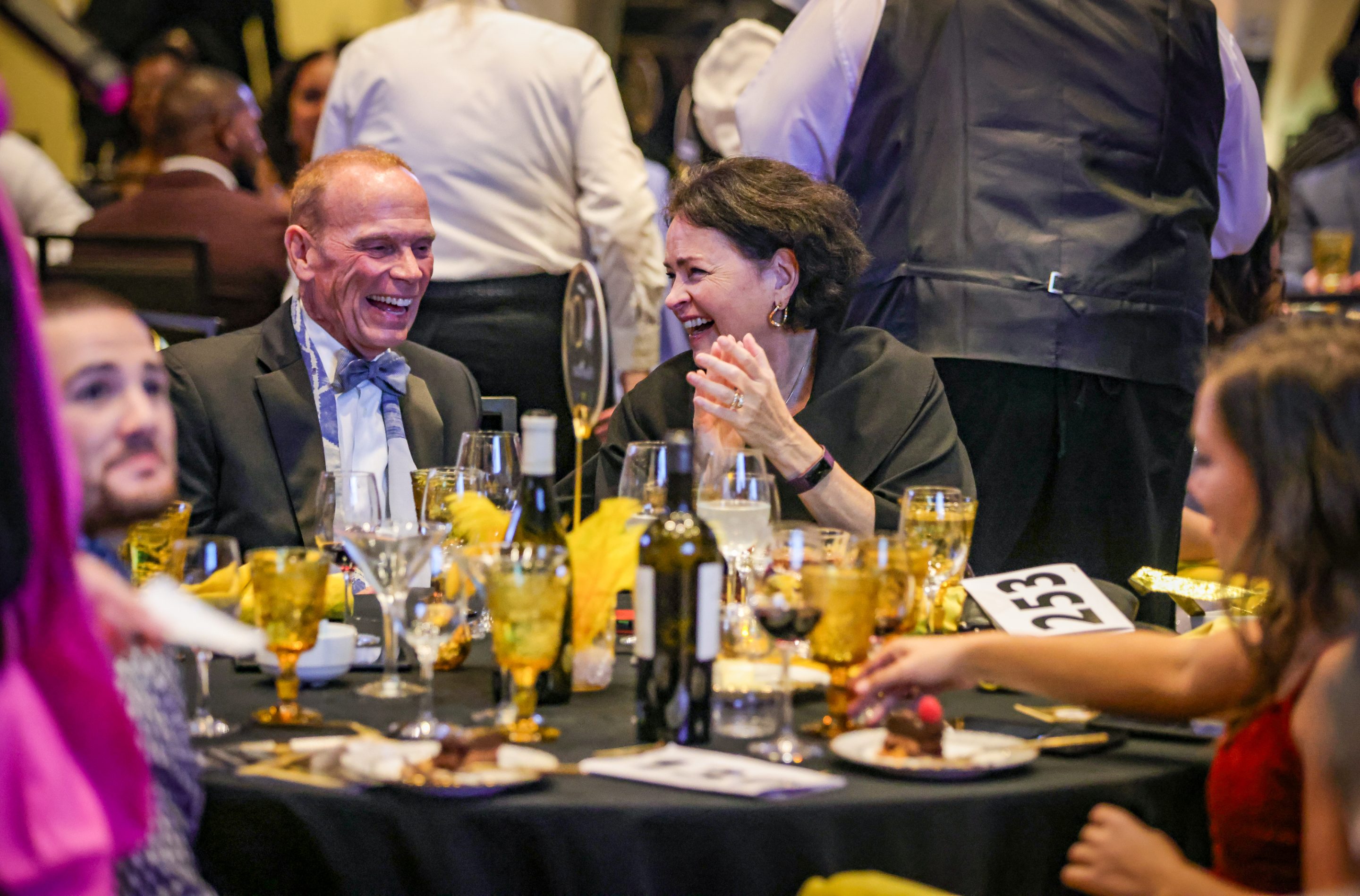 A group of people enjoying dinner together at Sonoma County Non-Profit Organization event and laughing.