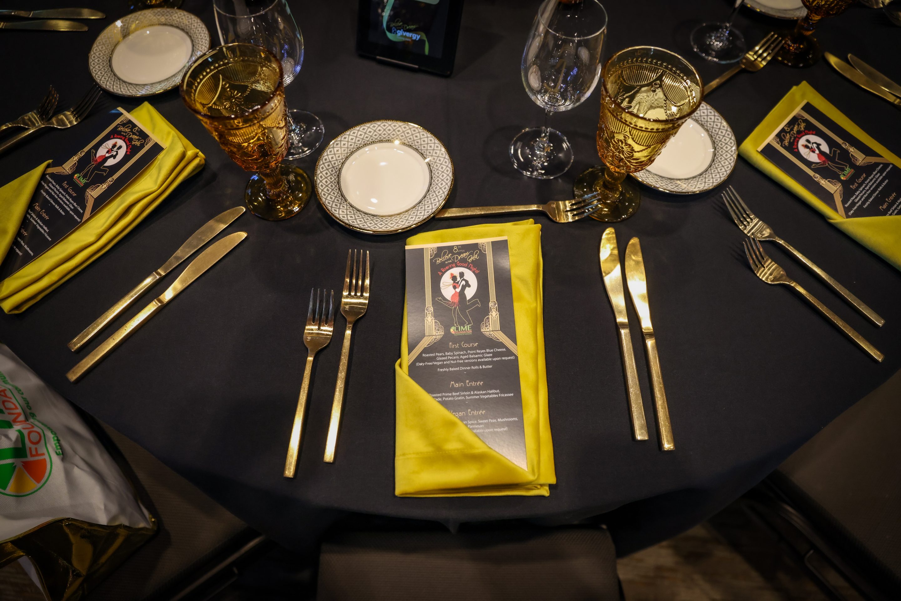 A table setting with napkins and forks on a black table at The LIME Foundation of Santa Rosa.