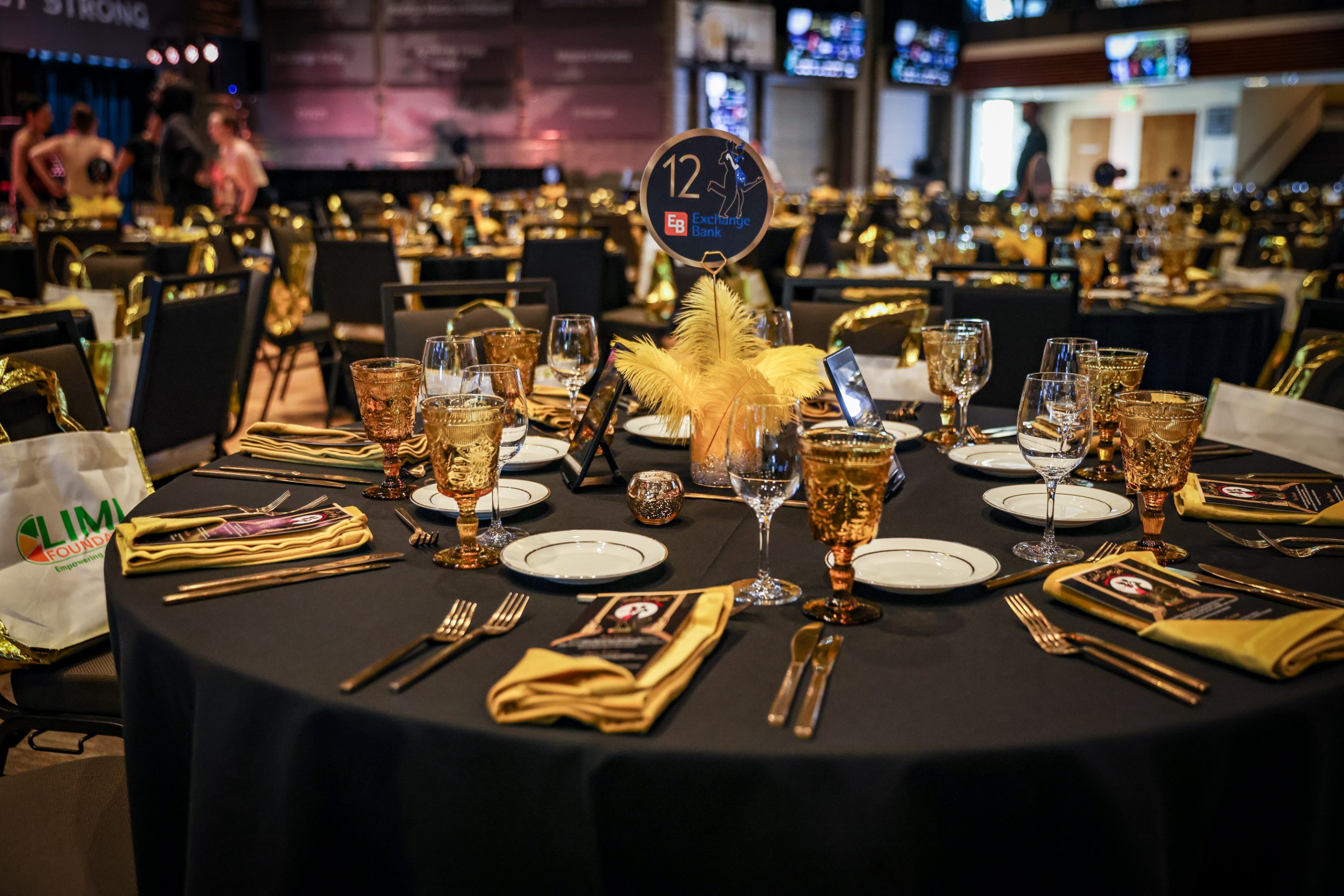 A black and gold table setting at a banquet hall for The LIME Foundation of Santa Rosa.