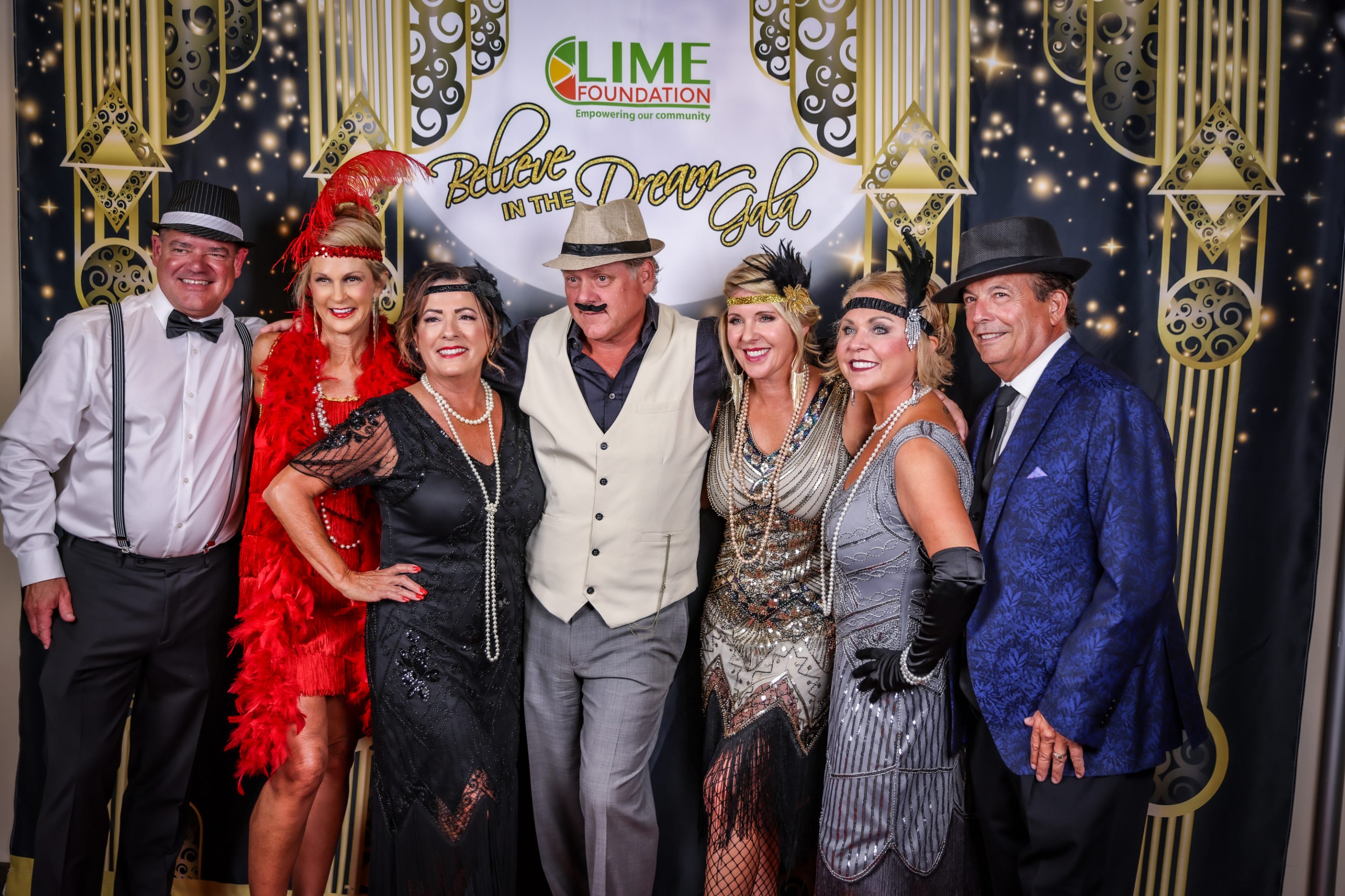 A group of people posing for a photo at a Gatsby themed party hosted by a Sonoma County non-profit organization.