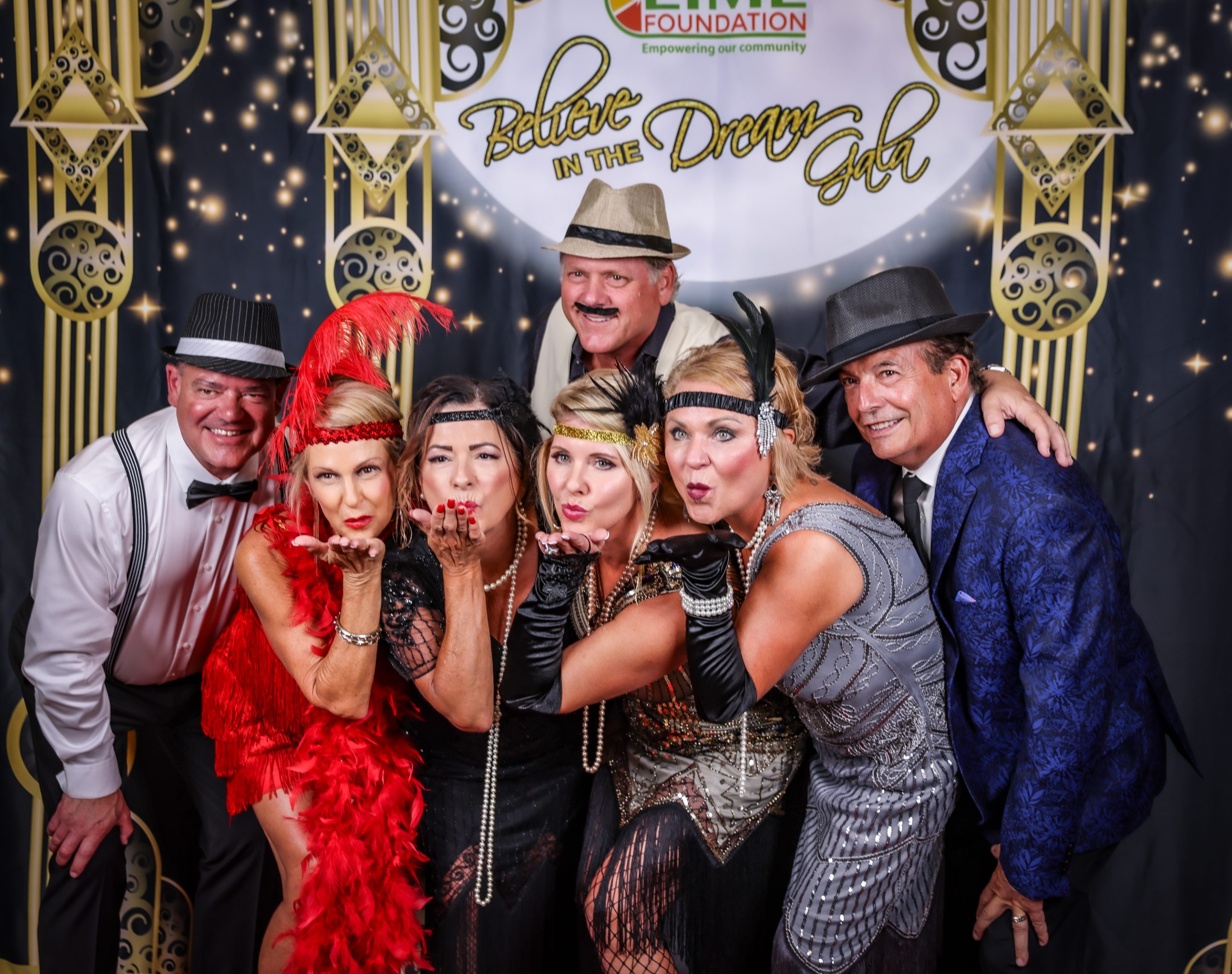 A group of people posing for a photo in a Gatsby-themed photo booth at an event hosted by Sonoma County Non-Profit Organization, The LIME Foundation.