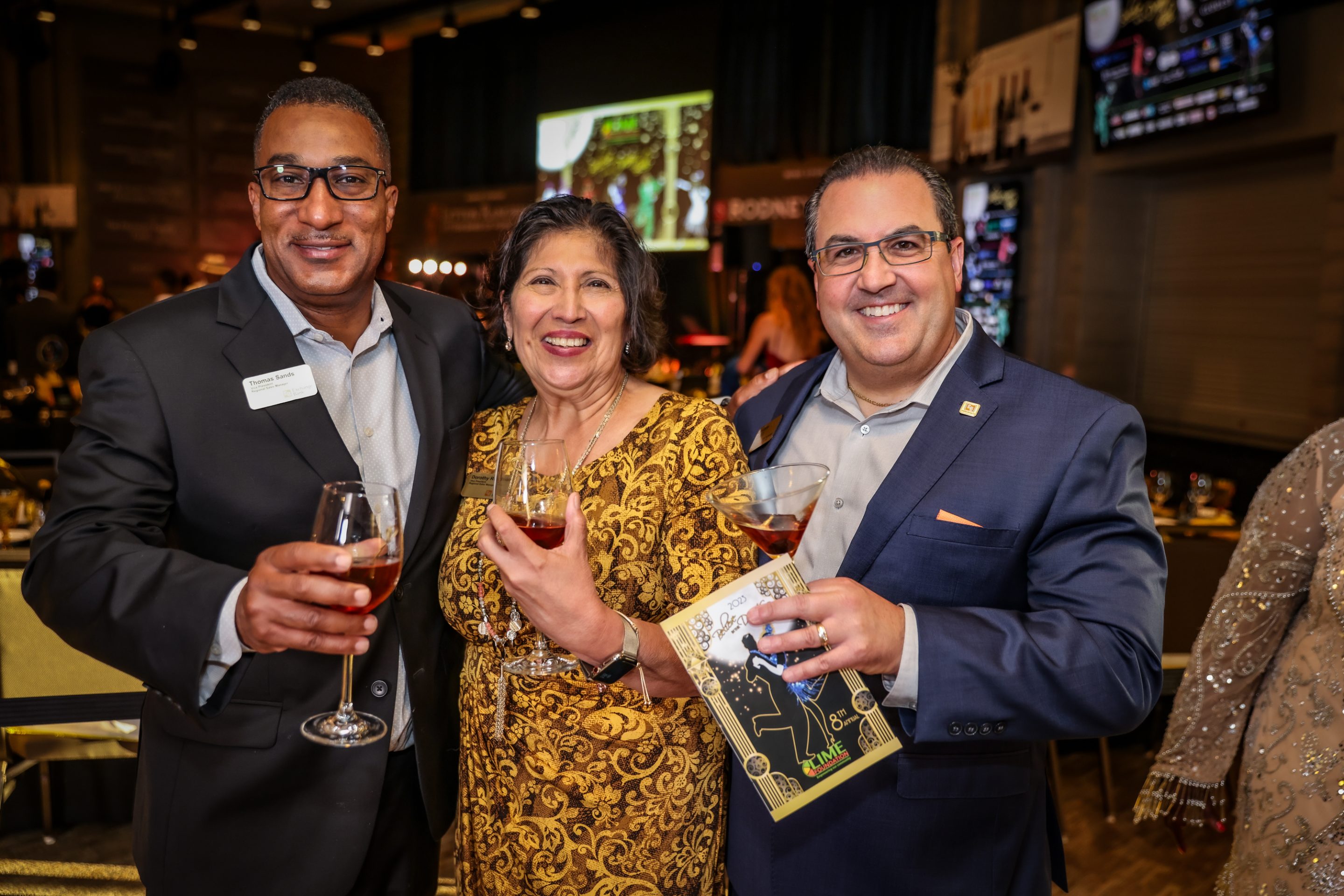 Three people from The LIME Foundation of Santa Rosa holding glasses of wine at an event.