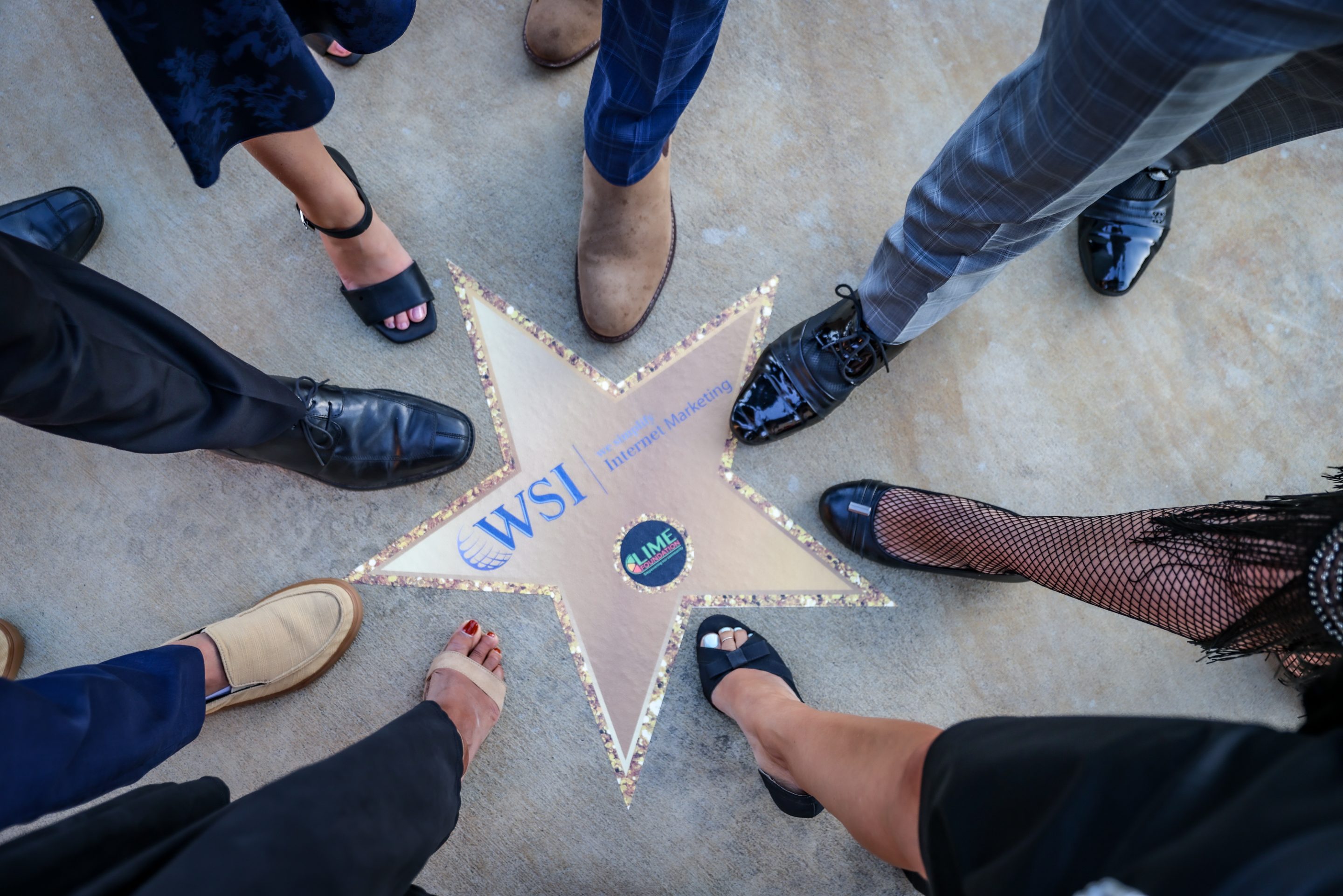 A group of people gathered around a star on the Hollywood Walk of Fame.