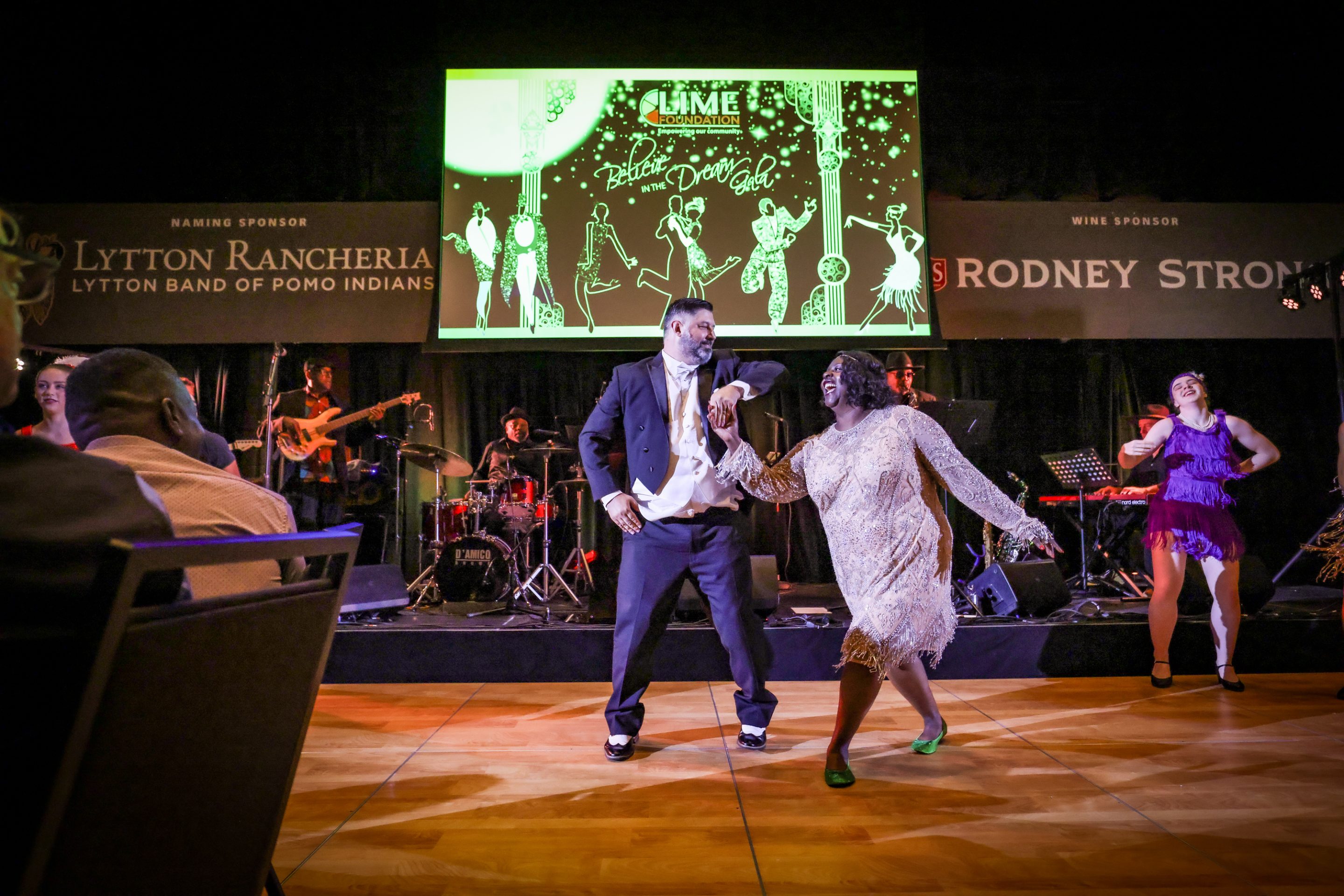 A man and woman dancing on stage at a Santa Rosa non-profit event hosted by The LIME Foundation.