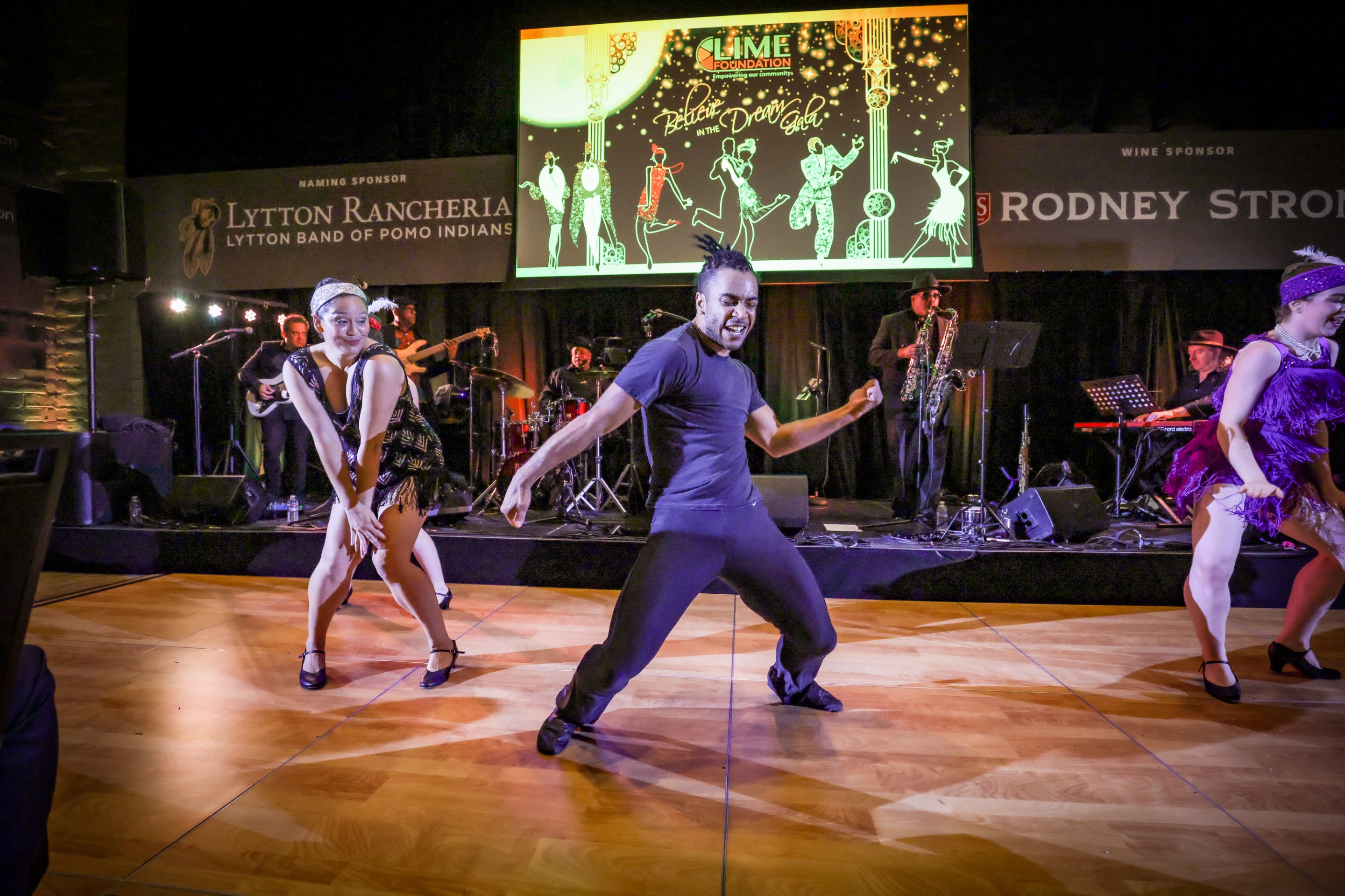A group of people dancing on stage at The LIME Foundation of Santa Rosa.