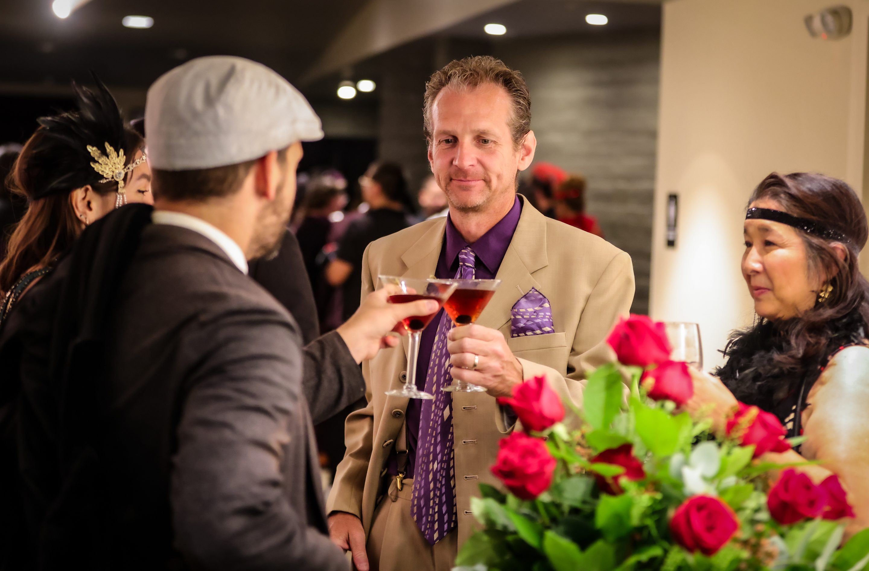 A man in a suit and tie is holding a glass of wine at a Sonoma County Non-Profit Organization event.