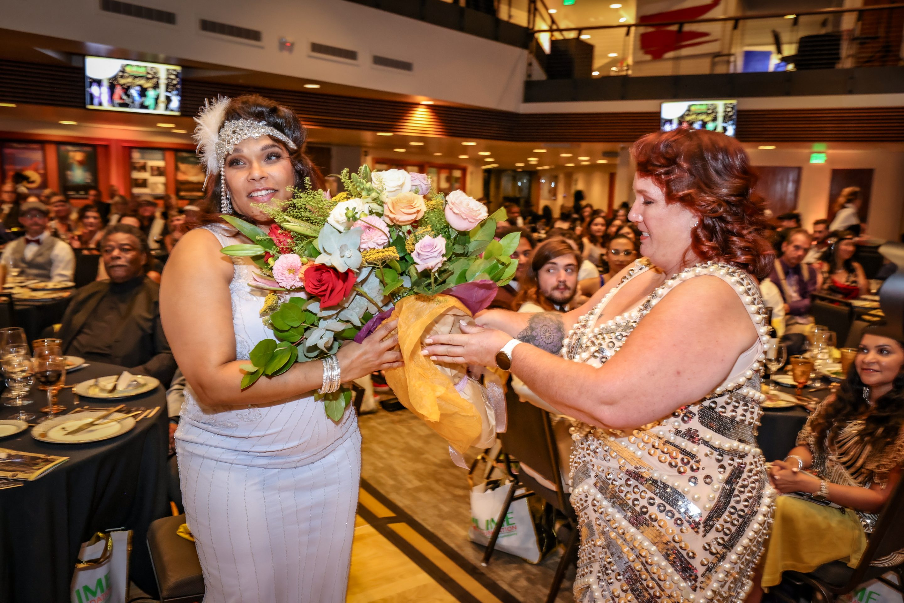 At an event, a woman is presenting a bouquet to another woman associated with The LIME Foundation of Santa Rosa.