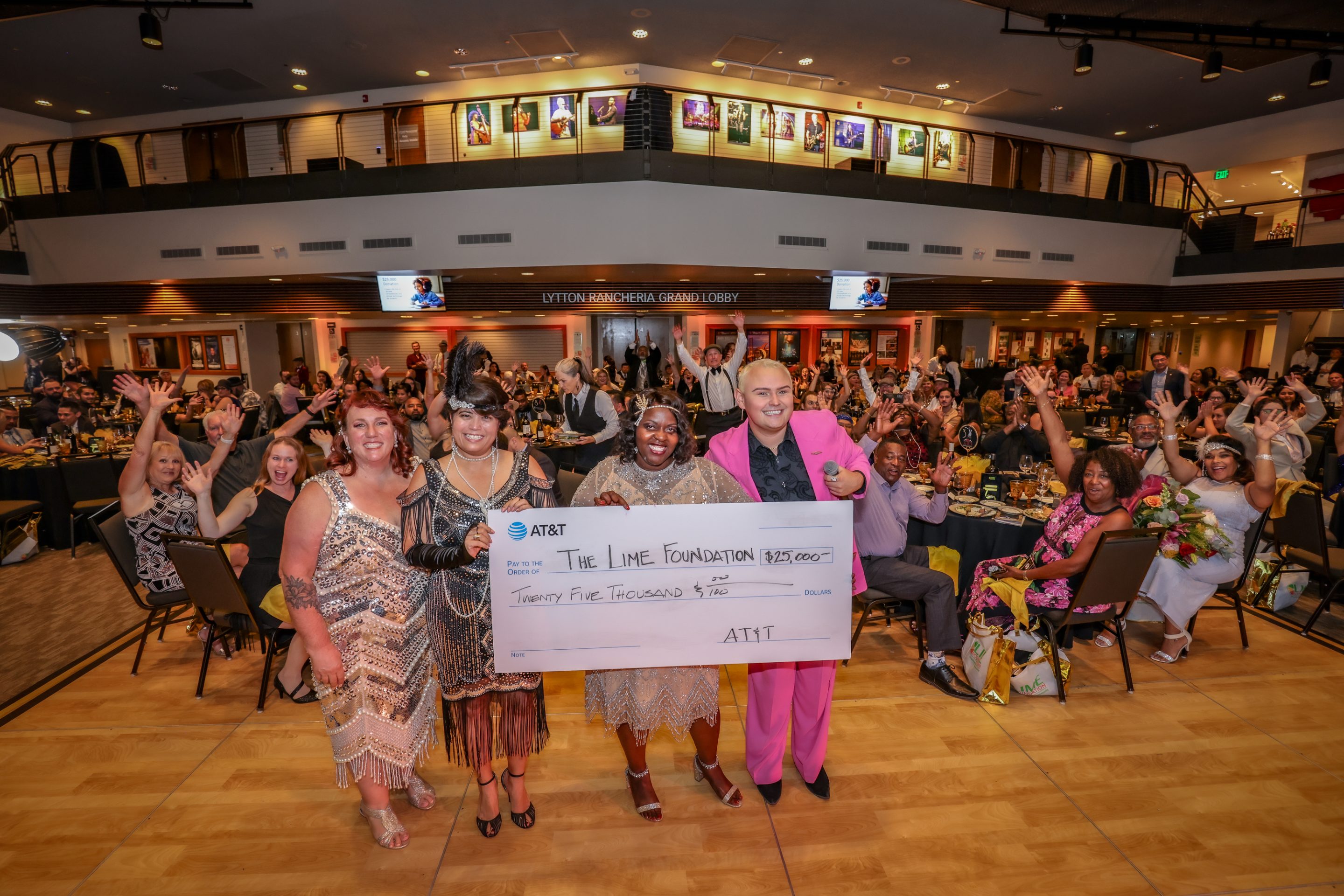 At a banquet, a group of people proudly hold up a check from the LIME Foundation of Santa Rosa.