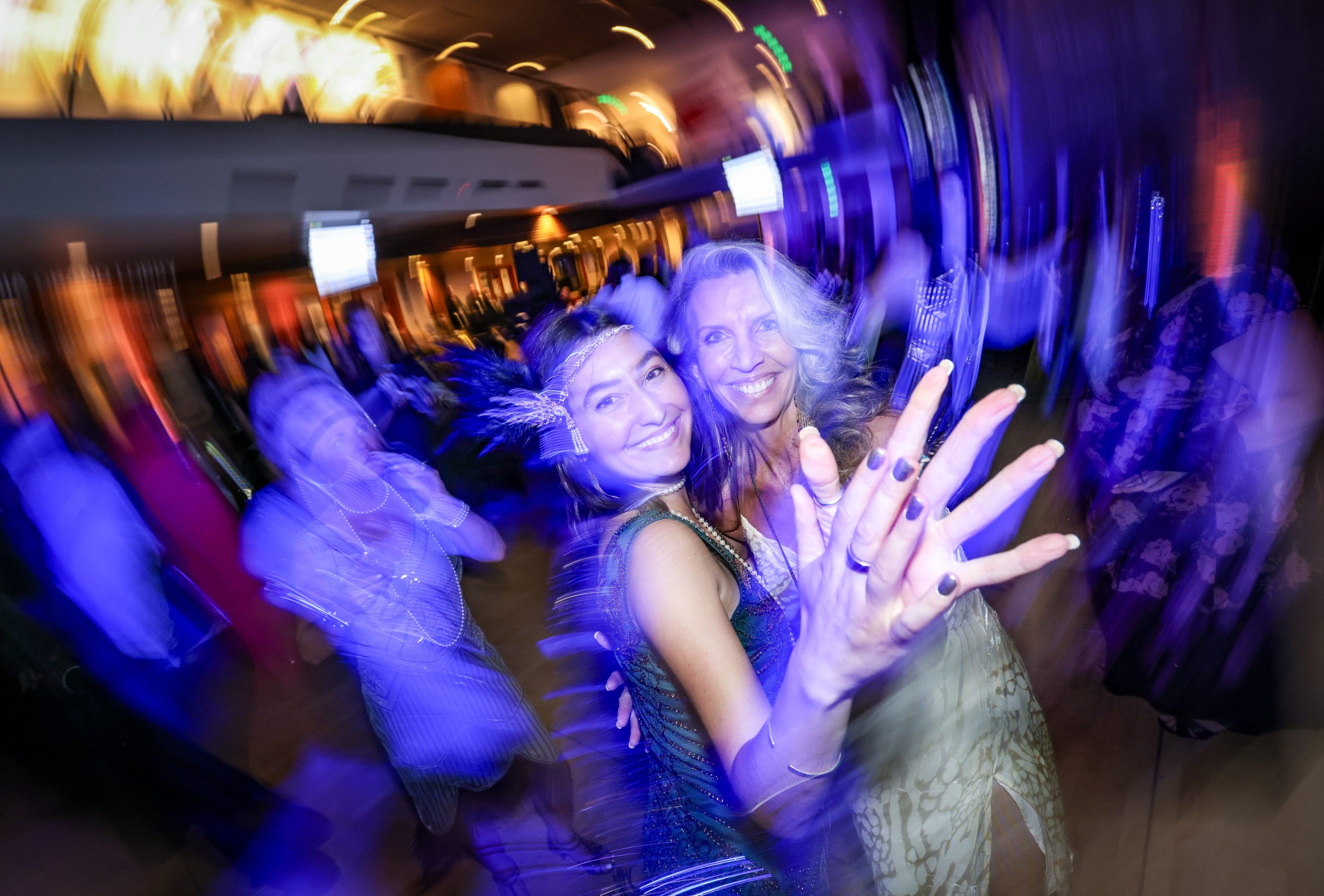 A blurry image of two women dancing at a party hosted by The LIME Foundation in Sonoma County.