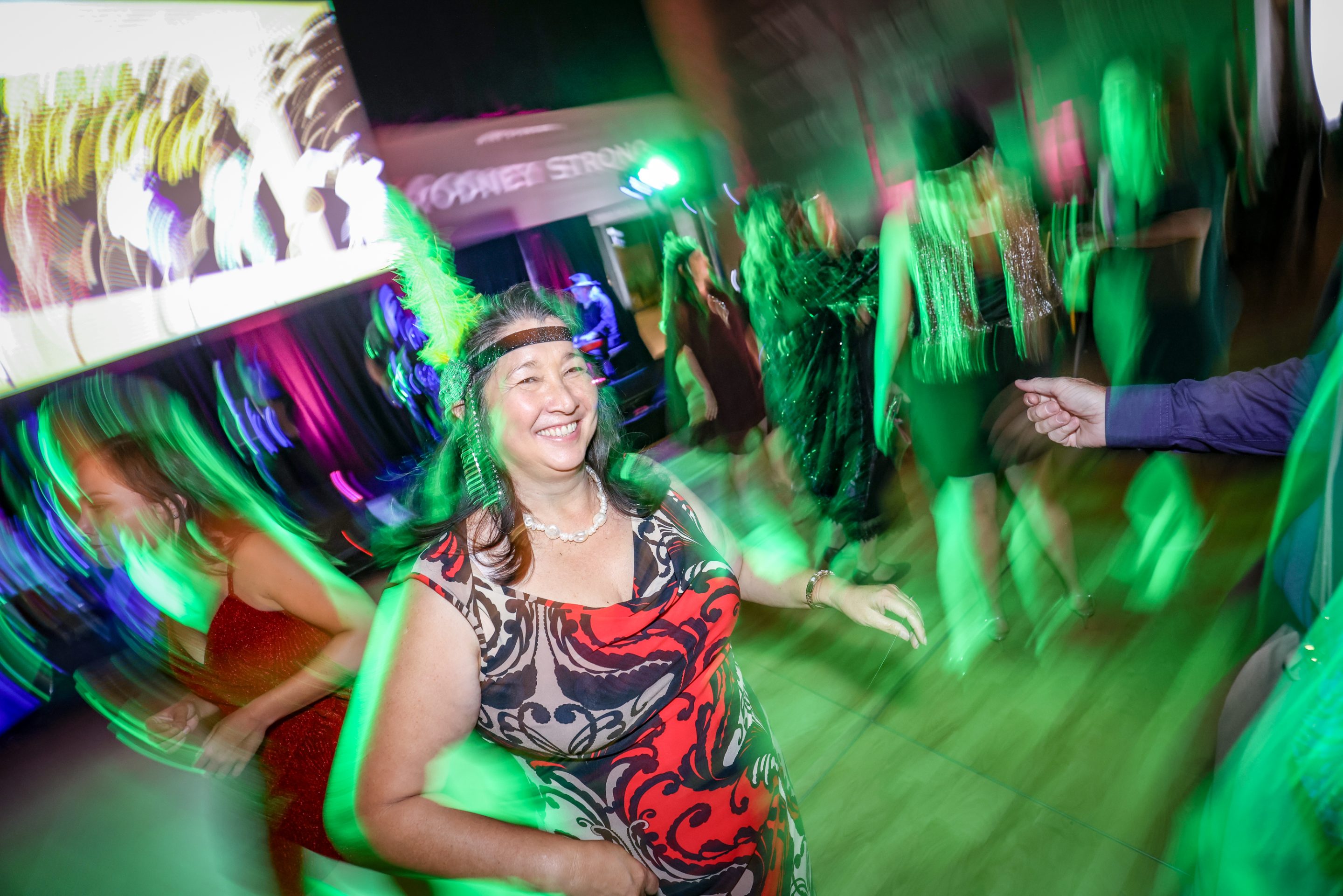 A woman dancing at a party with lime green lights.