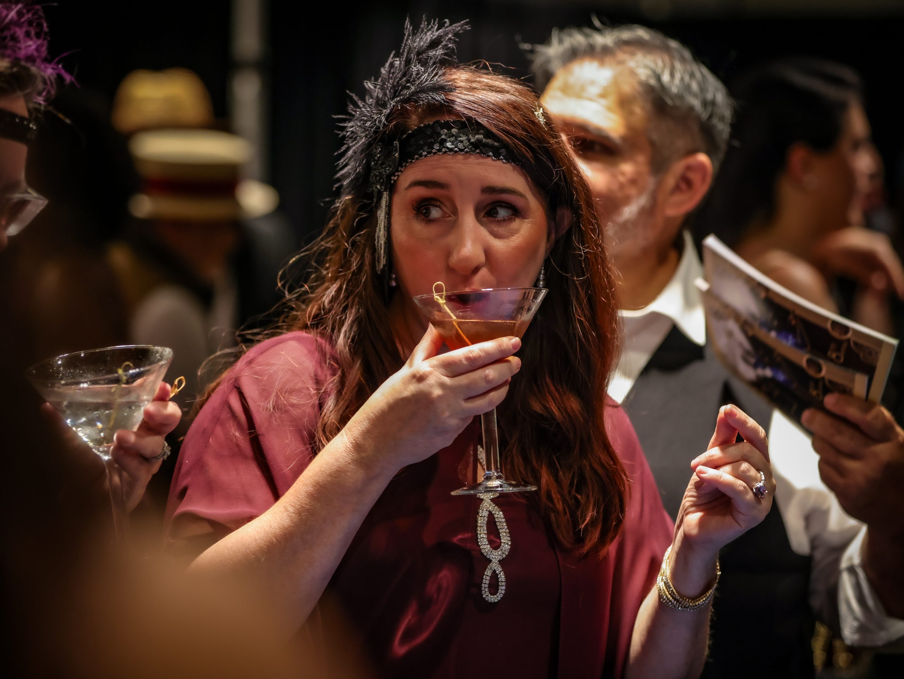 A woman enjoying a cocktail from a martini glass at a Santa Rosa Non-Profit event.