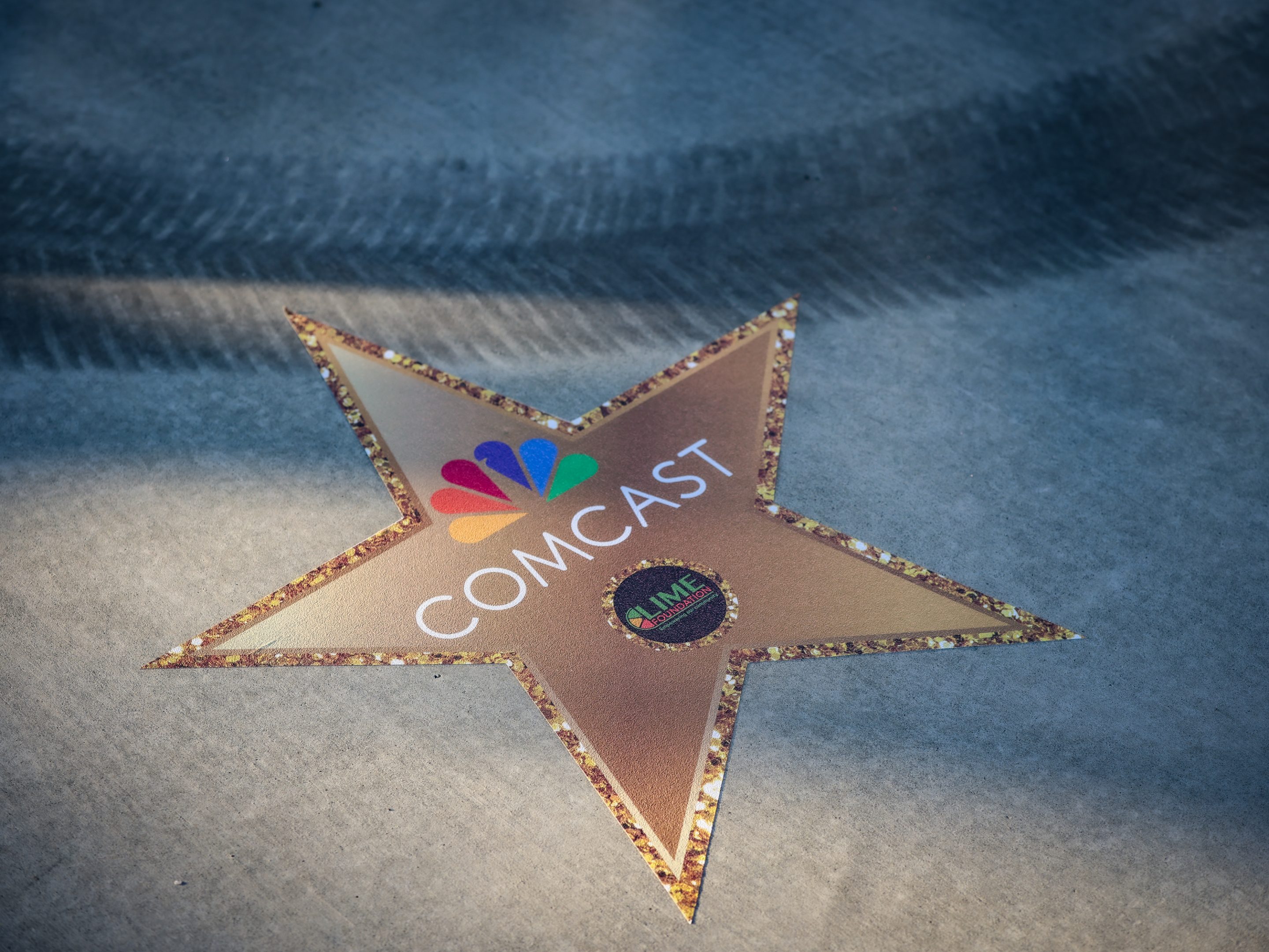 A gold star with the Comcast logo, sponsored by The LIME Foundation of Santa Rosa.