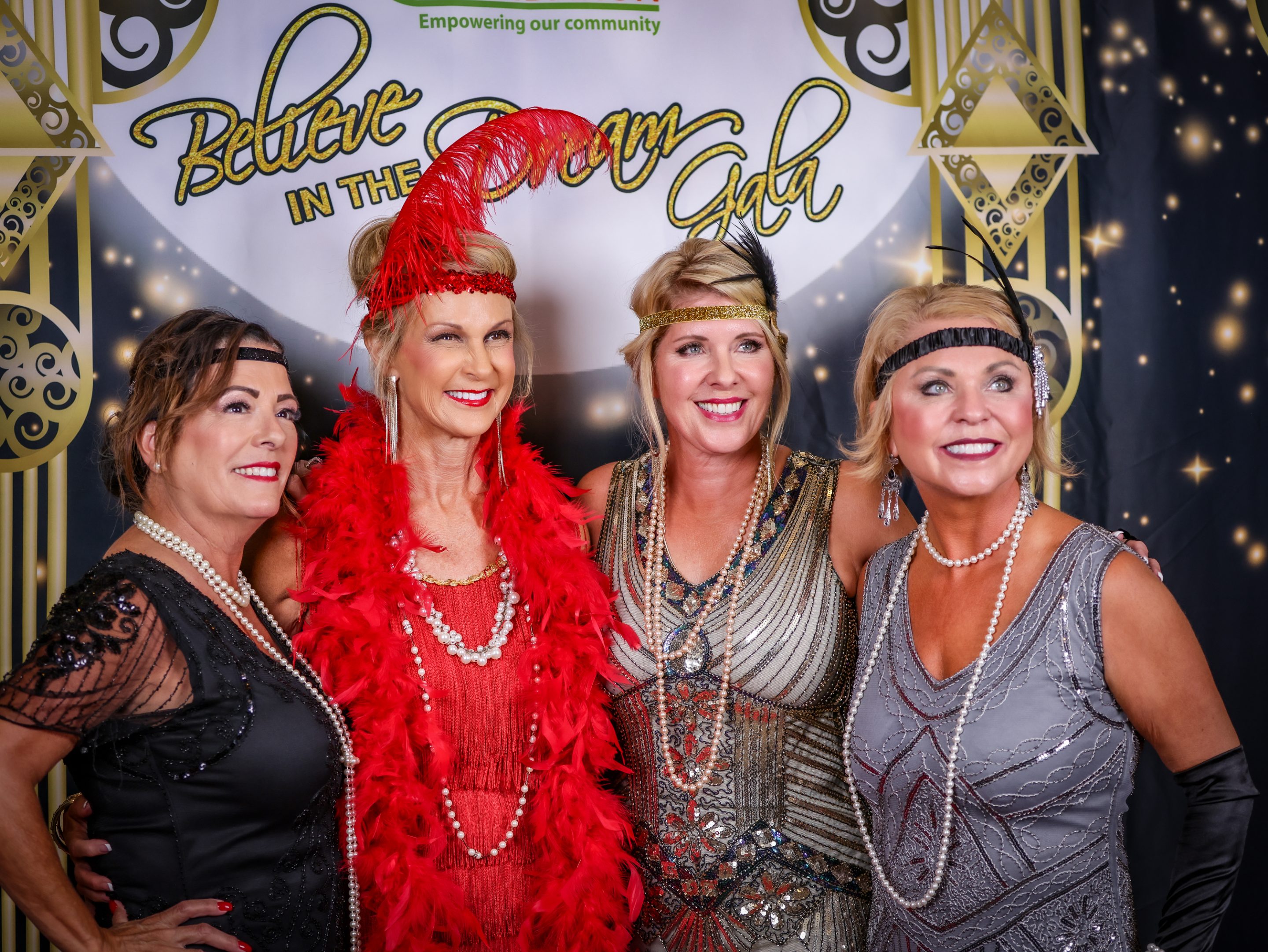 Four women are striking a pose at a Gatsby themed party hosted by The LIME Foundation of Santa Rosa.