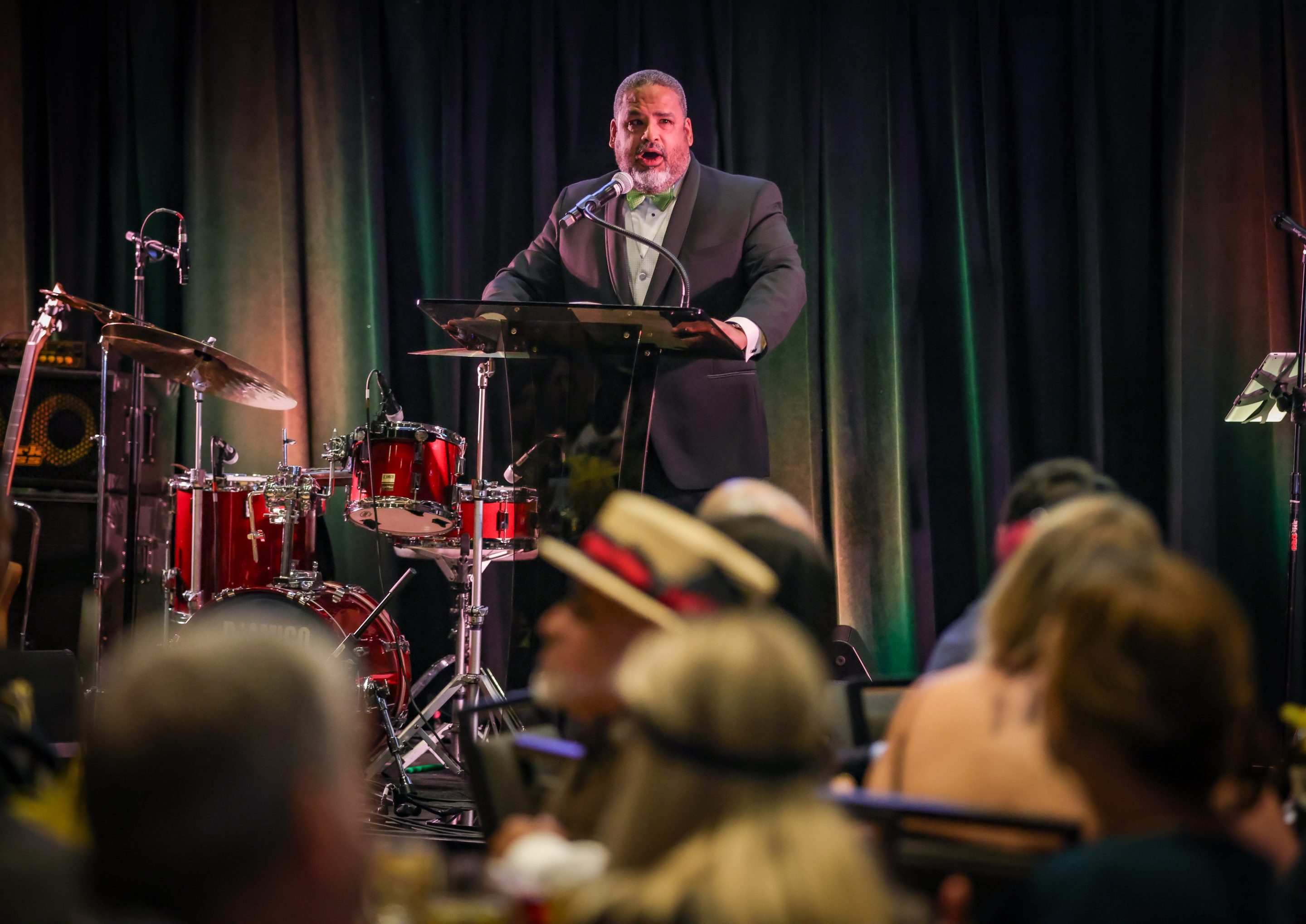 A man in a tuxedo giving a speech at The LIME Foundation event.