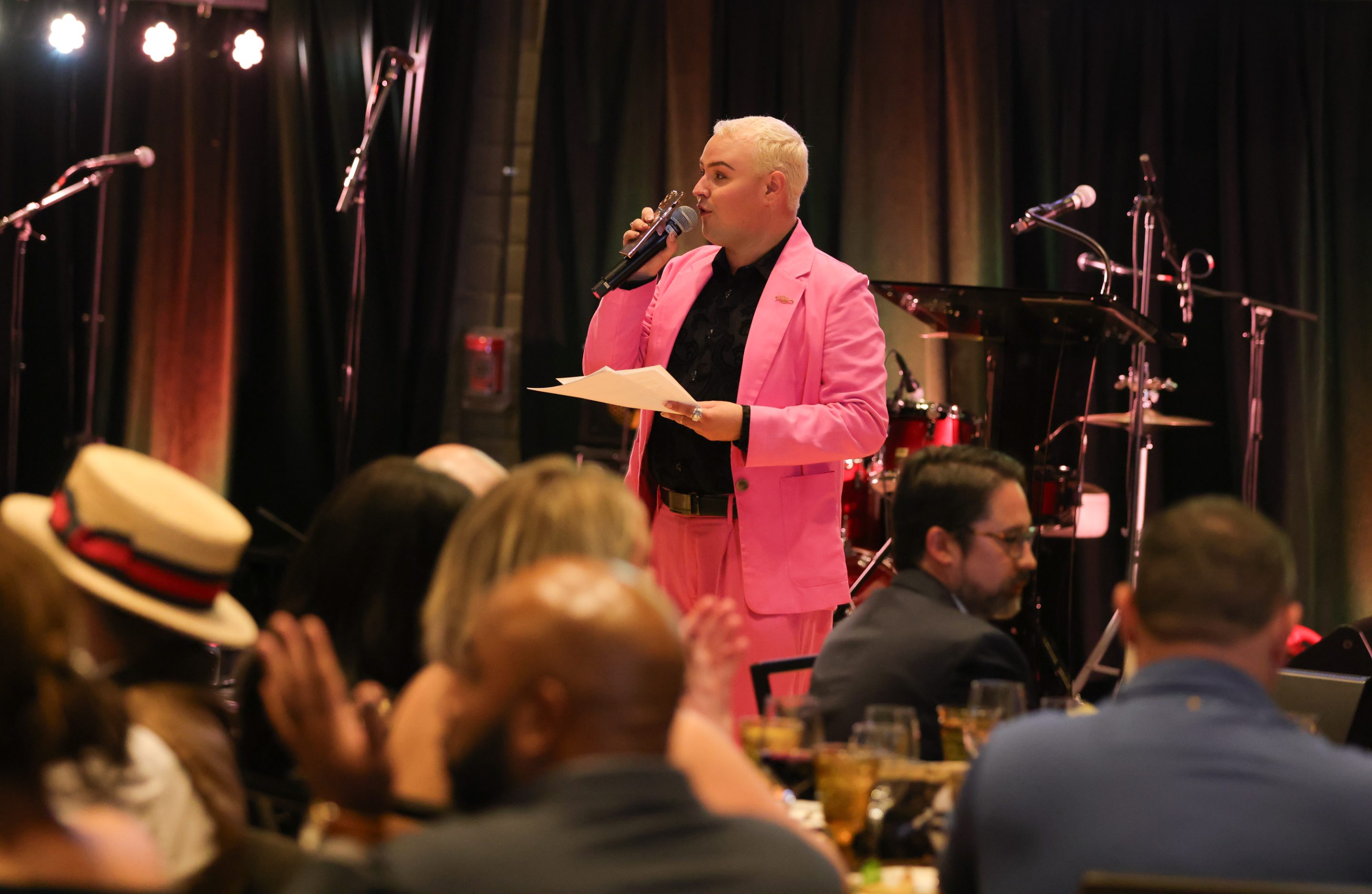 A man in a pink suit representing the LIME Foundation speaks into a microphone.