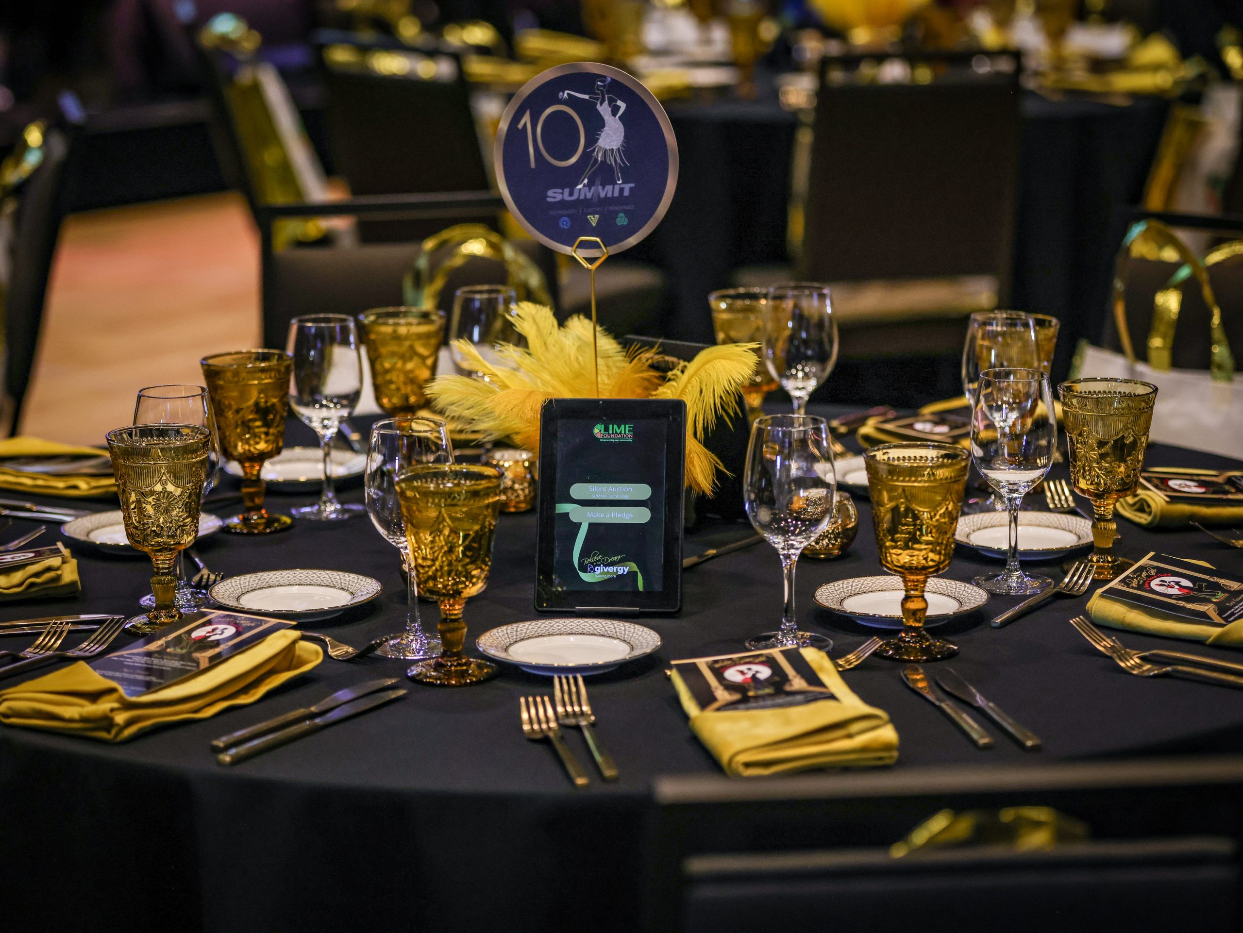 A black table setting with gold plates and napkins from The LIME Foundation of Santa Rosa.