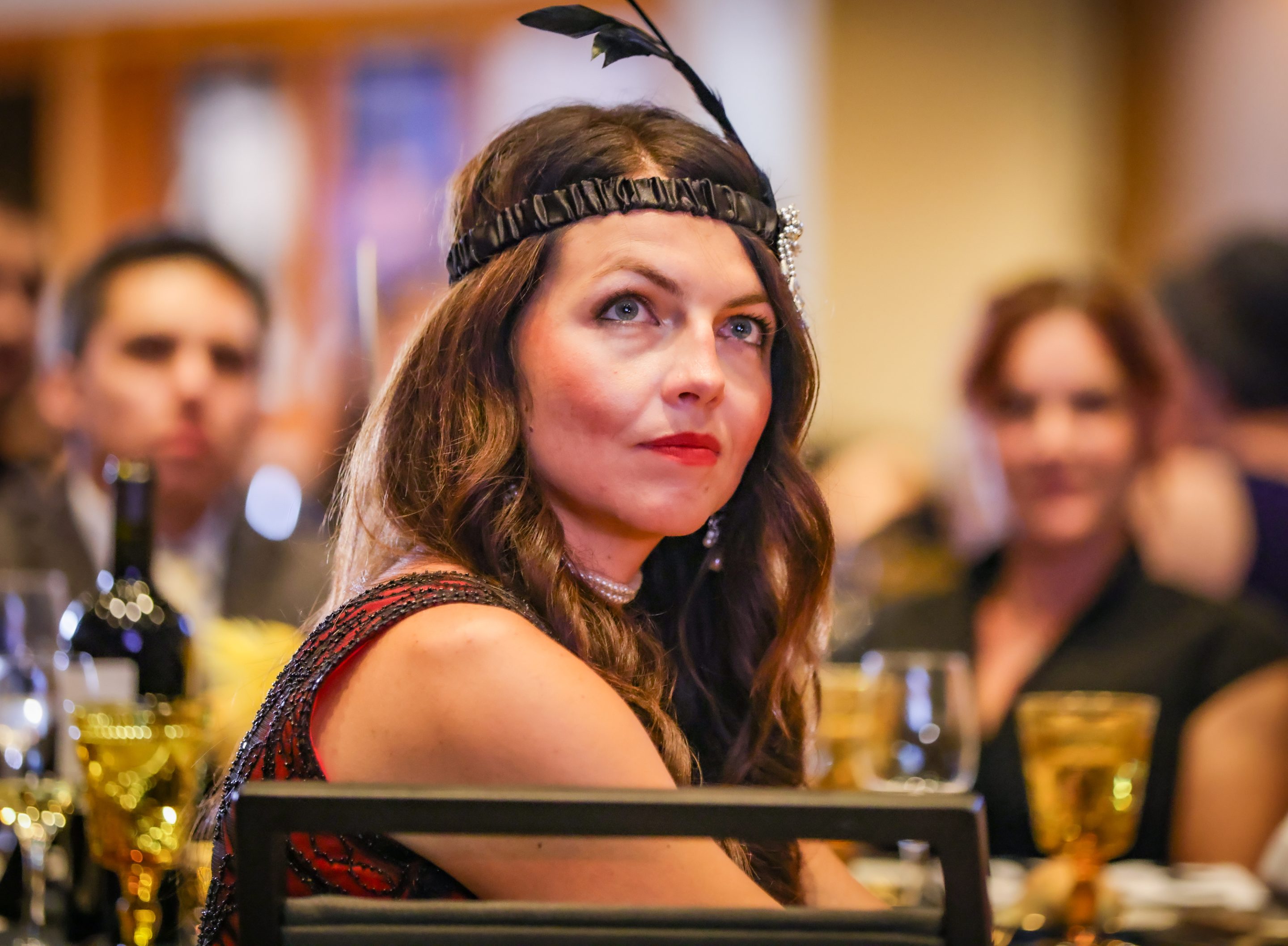 A woman sitting at a table wearing a flapper hat in Sonoma County.
