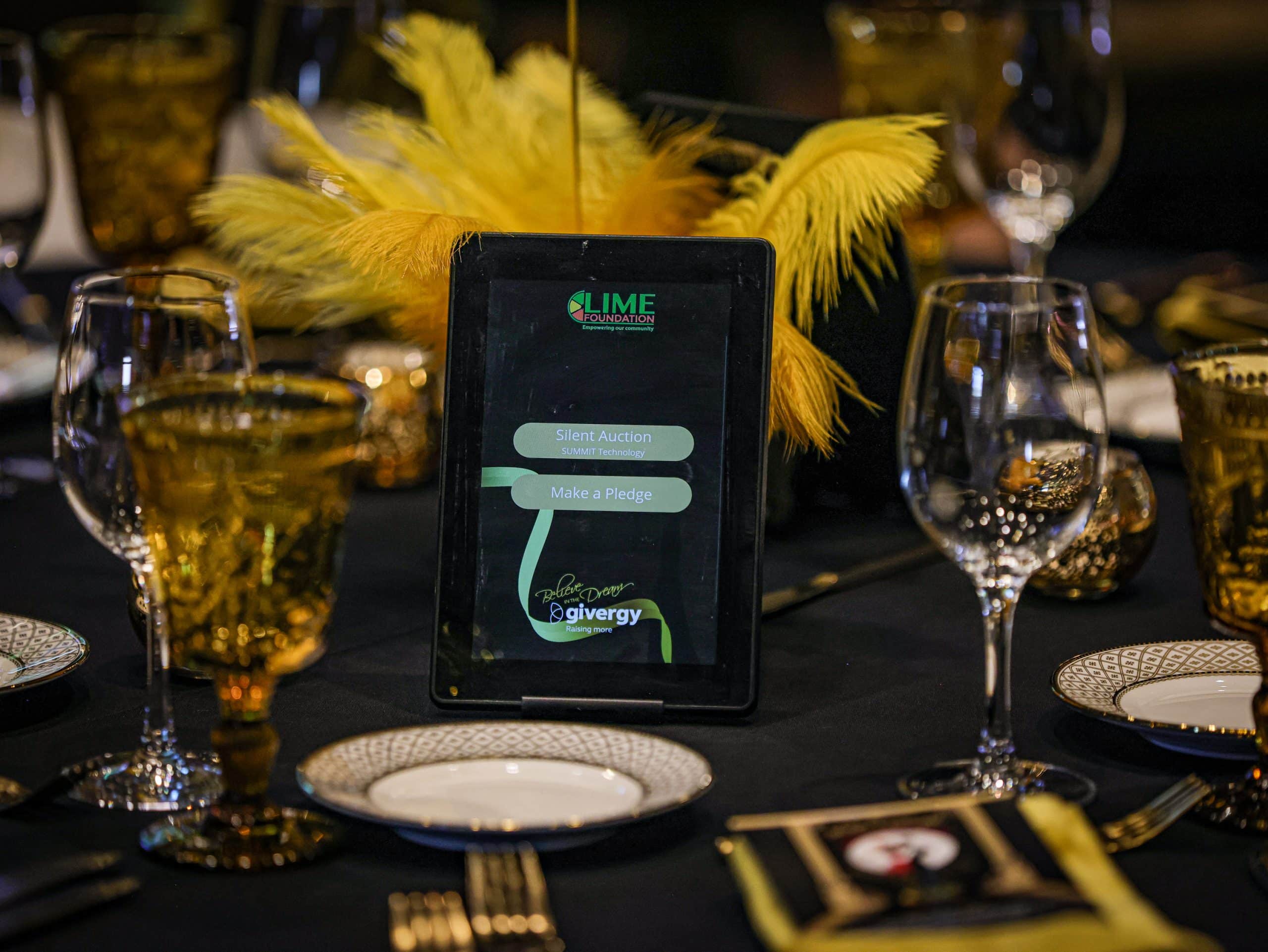 A black and gold table setting with a tablet on it at the Sonoma County Non-Profit Organization.