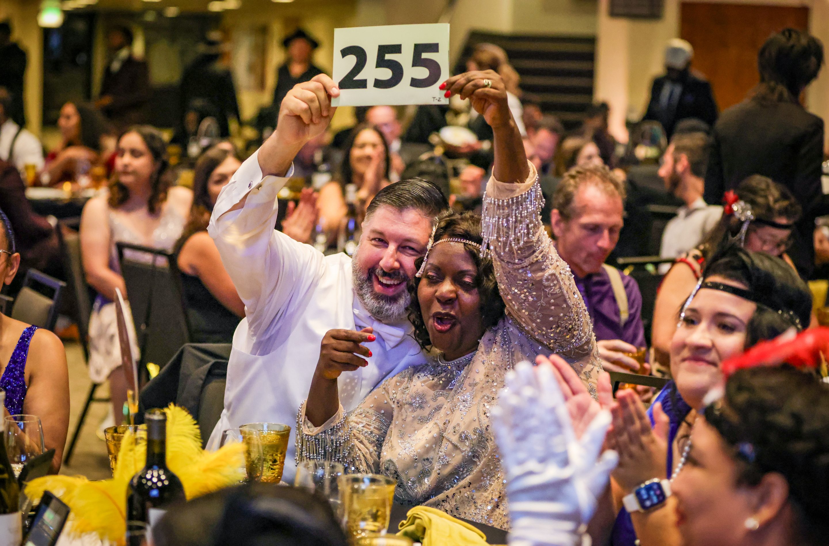 A group of people from The LIME Foundation of Santa Rosa holding up a number at a banquet.