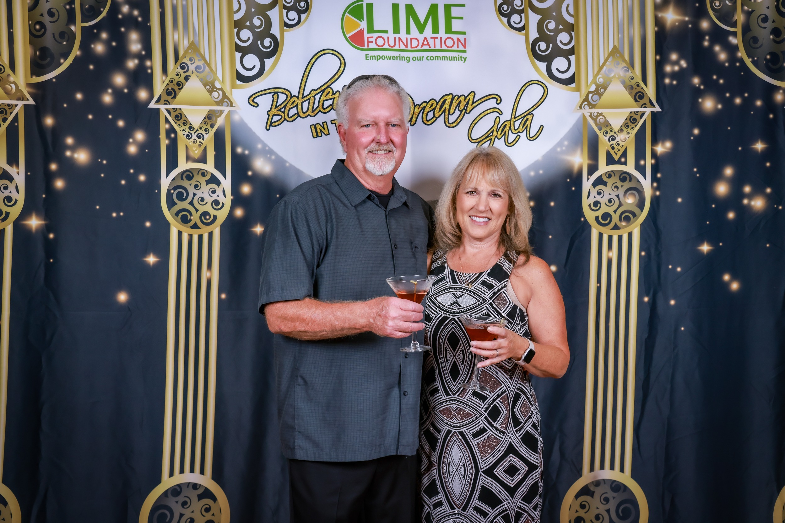 A man and woman posing for a photo in front of a backdrop at the LIME Foundation event.