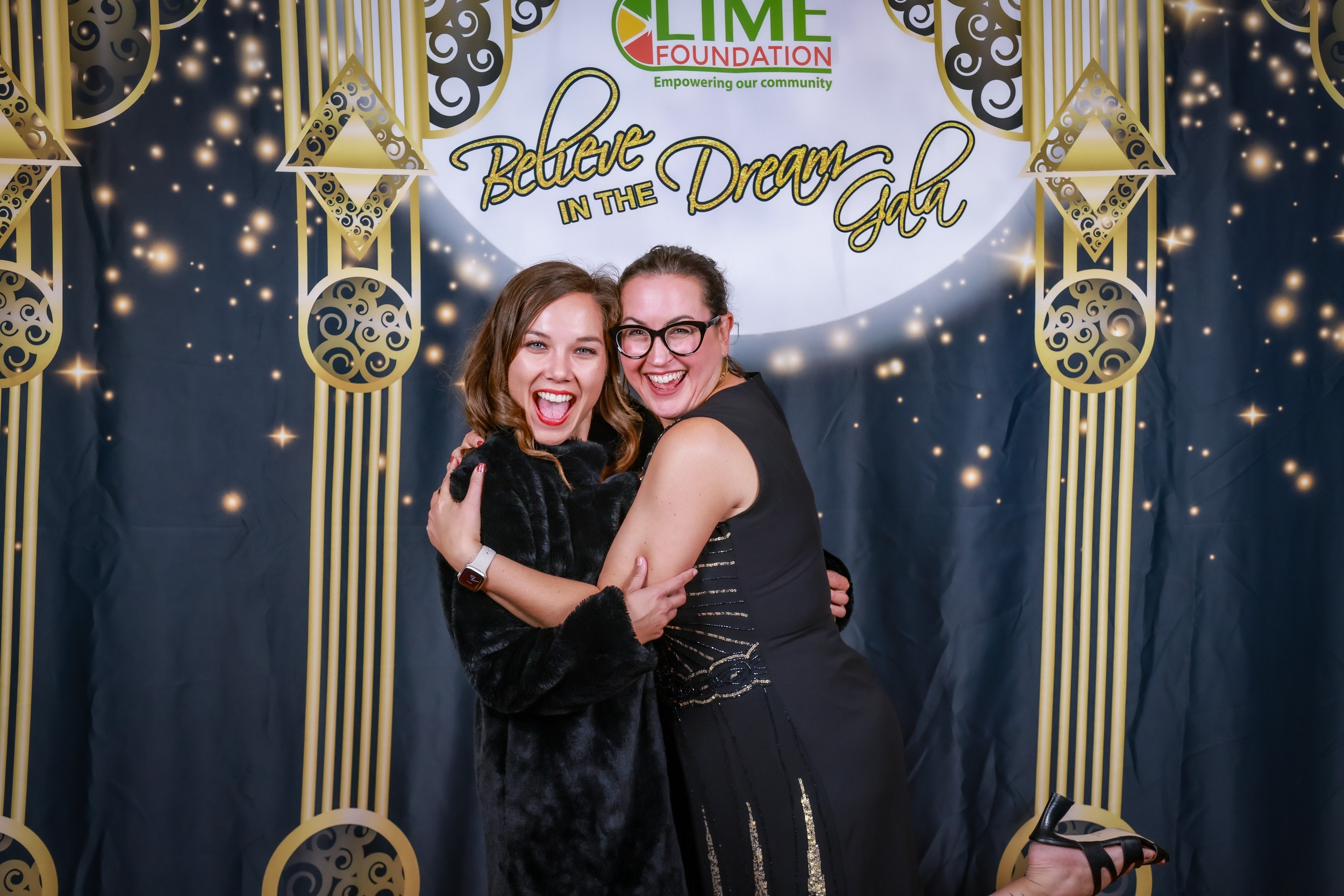 Two women from Sonoma County posing for a photo at a photo booth run by The LIME Foundation.