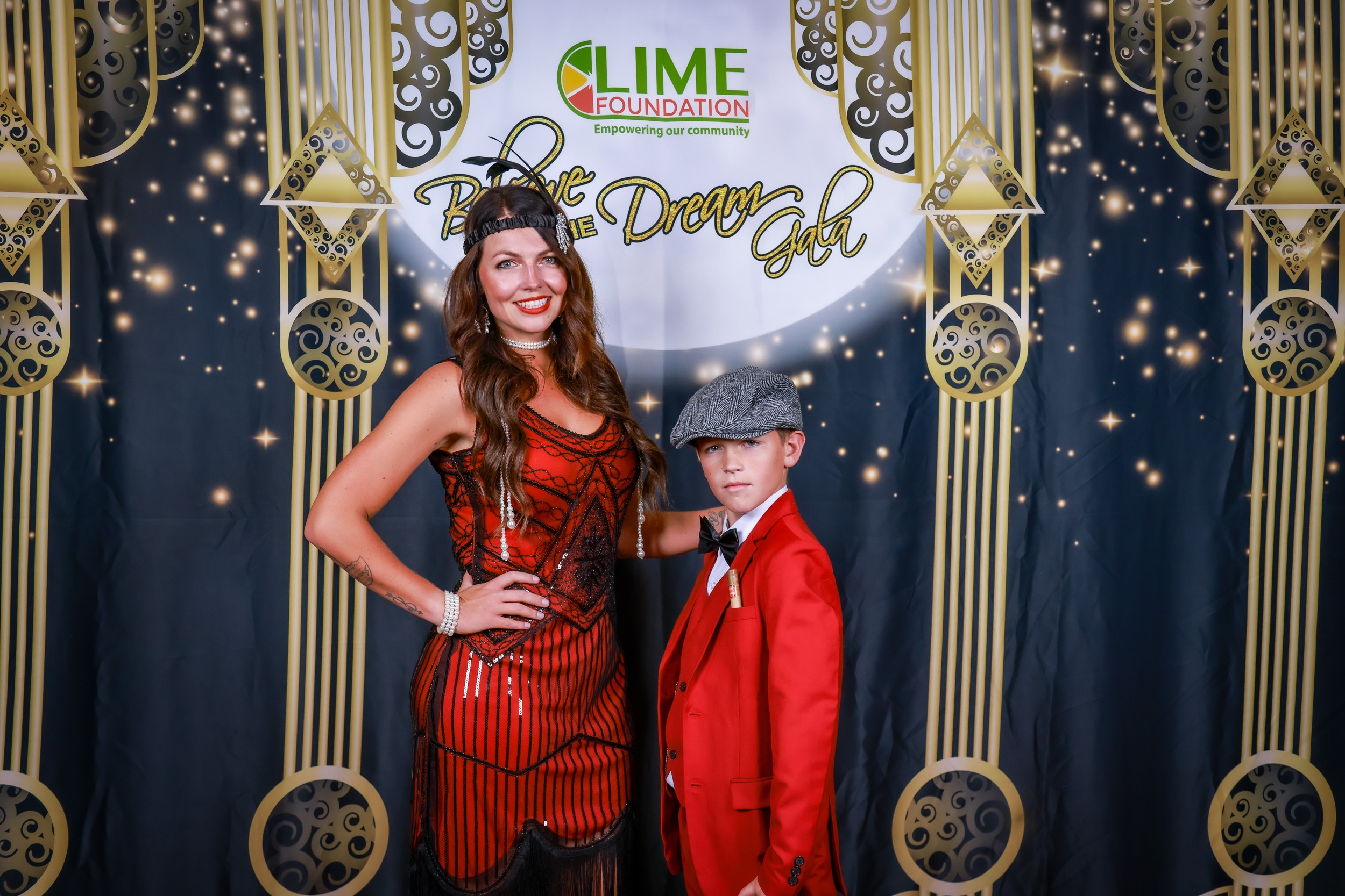 A woman and a boy posing for a photo at The LIME Foundation of Santa Rosa in a red dress.