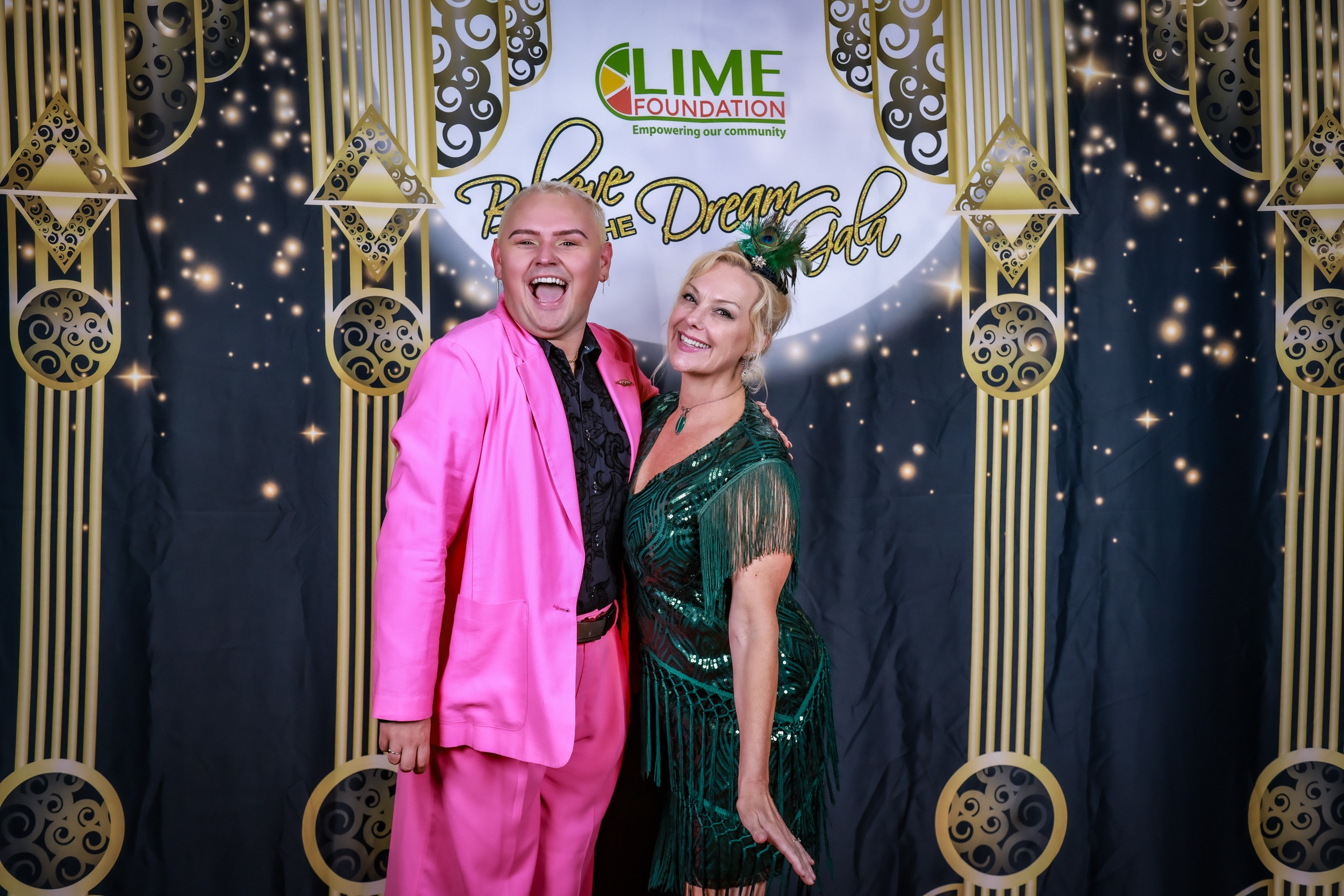 A man and woman posing for a photo in pink outfits at The LIME Foundation of Santa Rosa.