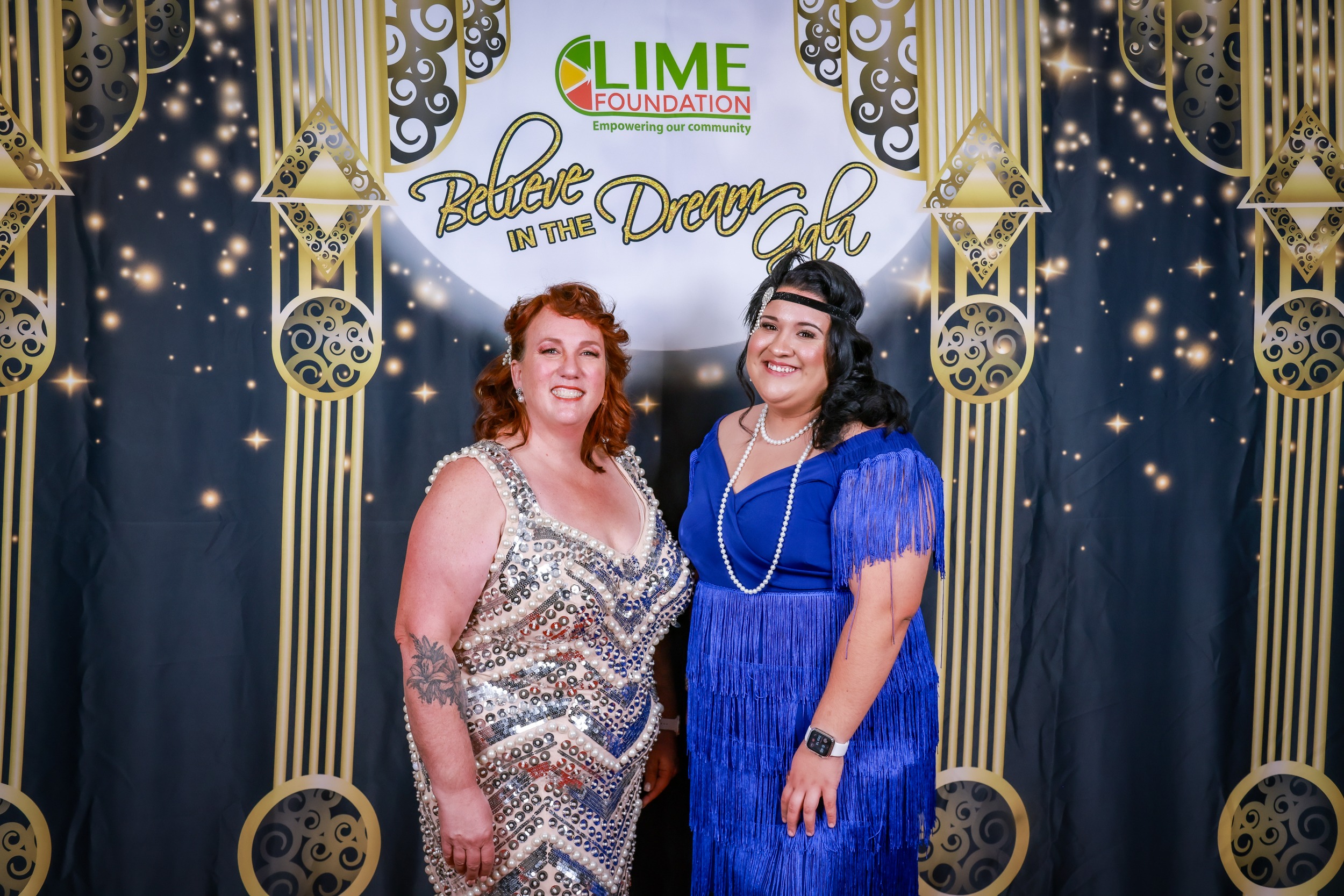 Two women posing for a photo at a 1920's themed party hosted by The LIME Foundation of Santa Rosa, a Sonoma County Non-Profit Organization.