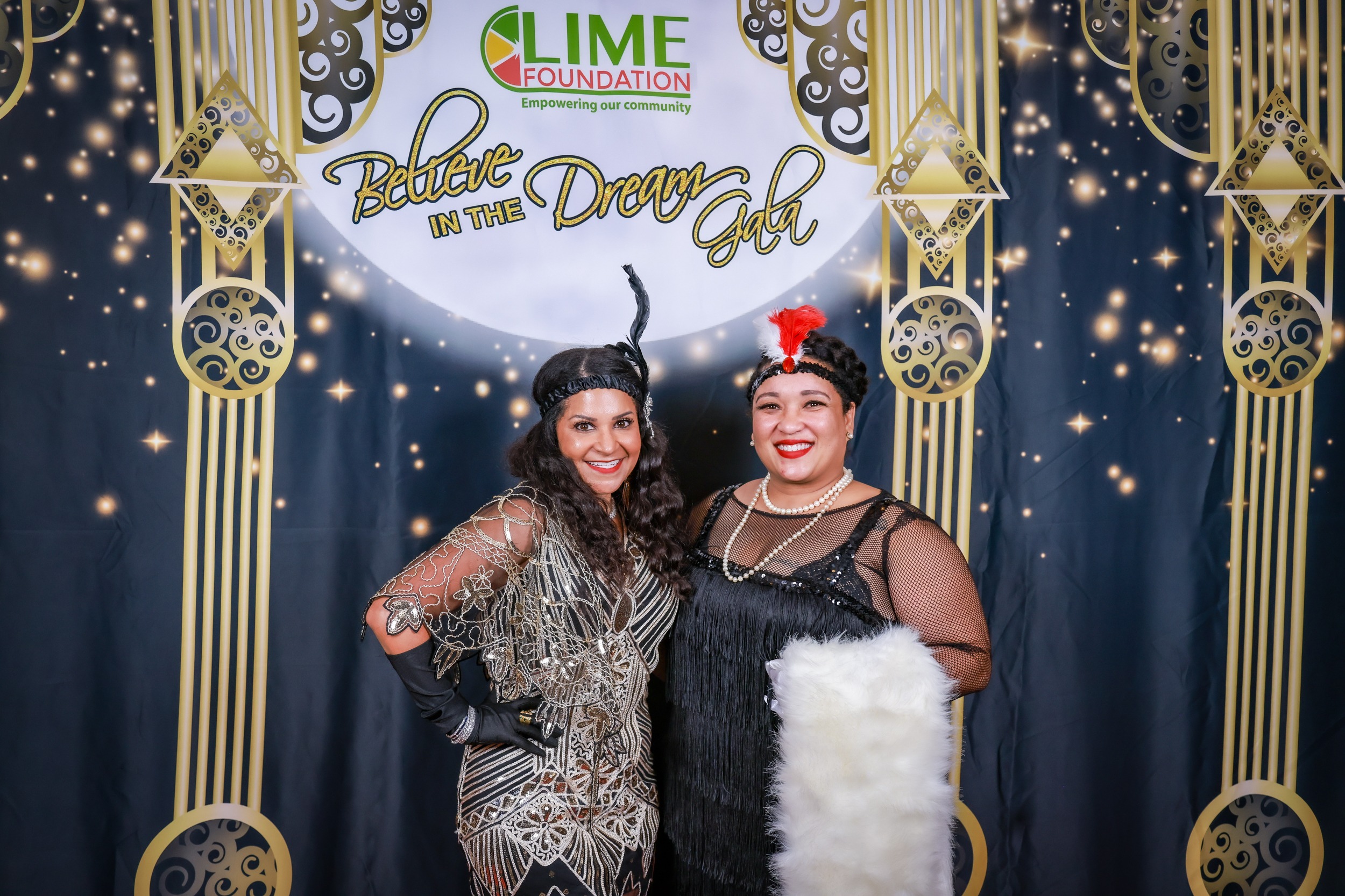 Two women striking a pose at a 1920's themed party sponsored by The LIME Foundation of Santa Rosa.