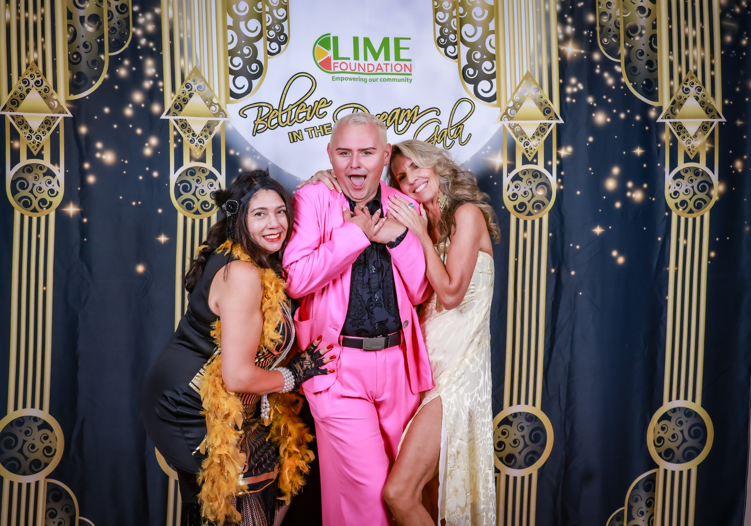 A man in a pink suit and a woman in a pink dress posing for a photo at The LIME Foundation of Santa Rosa, a Sonoma County Non-Profit Organization.