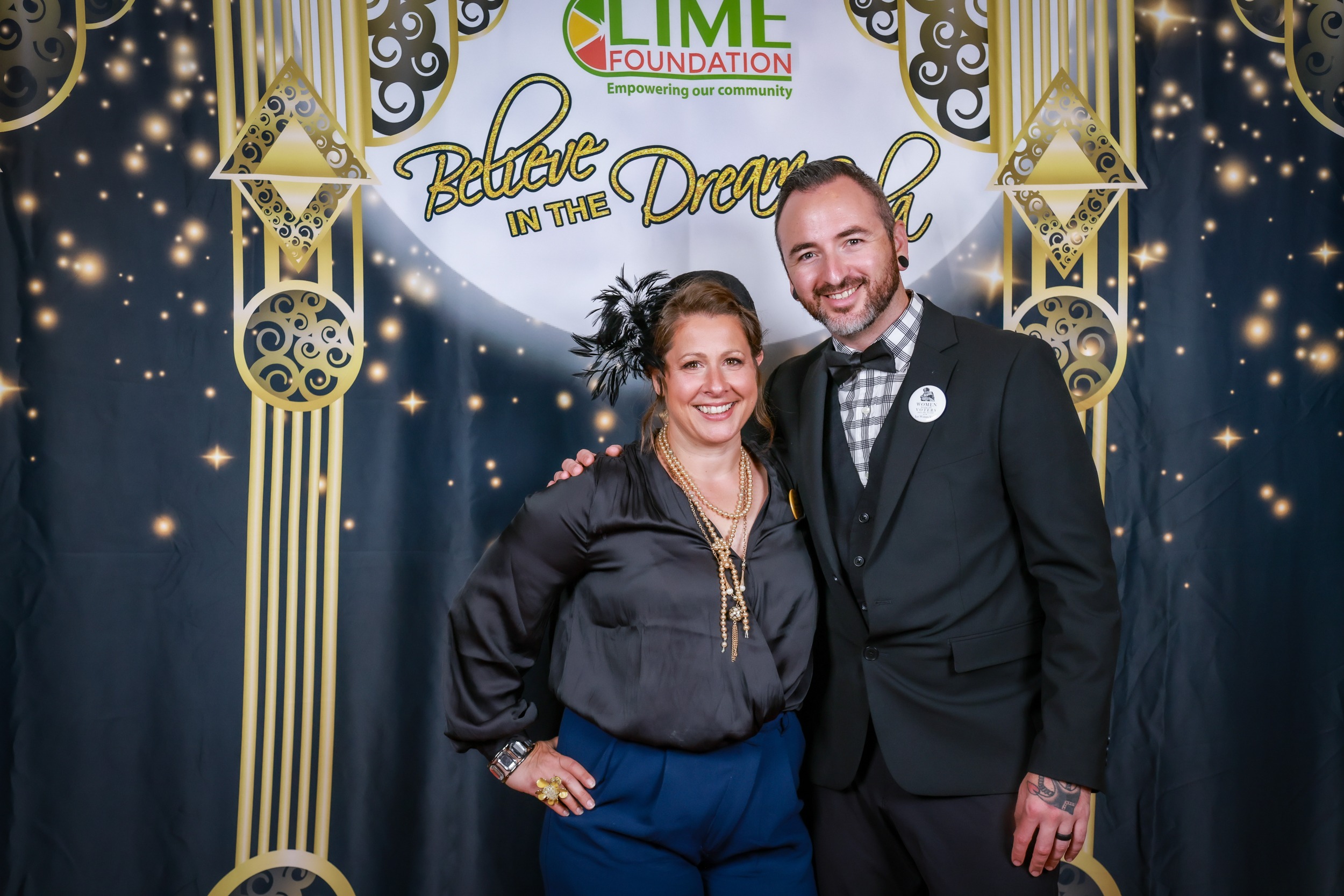 A man and woman posing for a photo in front of a backdrop at a Sonoma County Non-Profit Organization event hosted by The LIME Foundation of Santa Rosa.