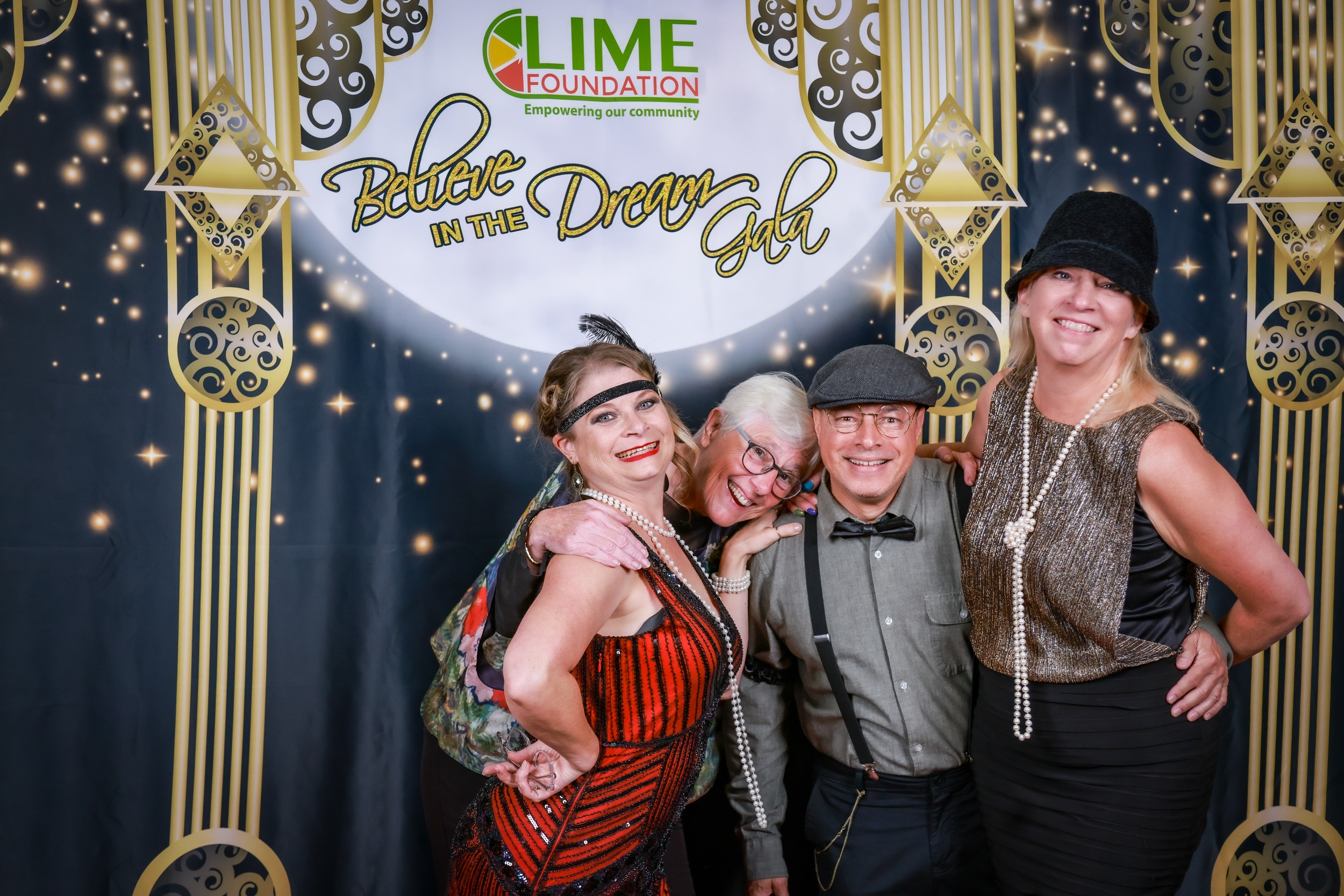 A group of people posing for a photo at a 1920s themed party hosted by the LIME Foundation.