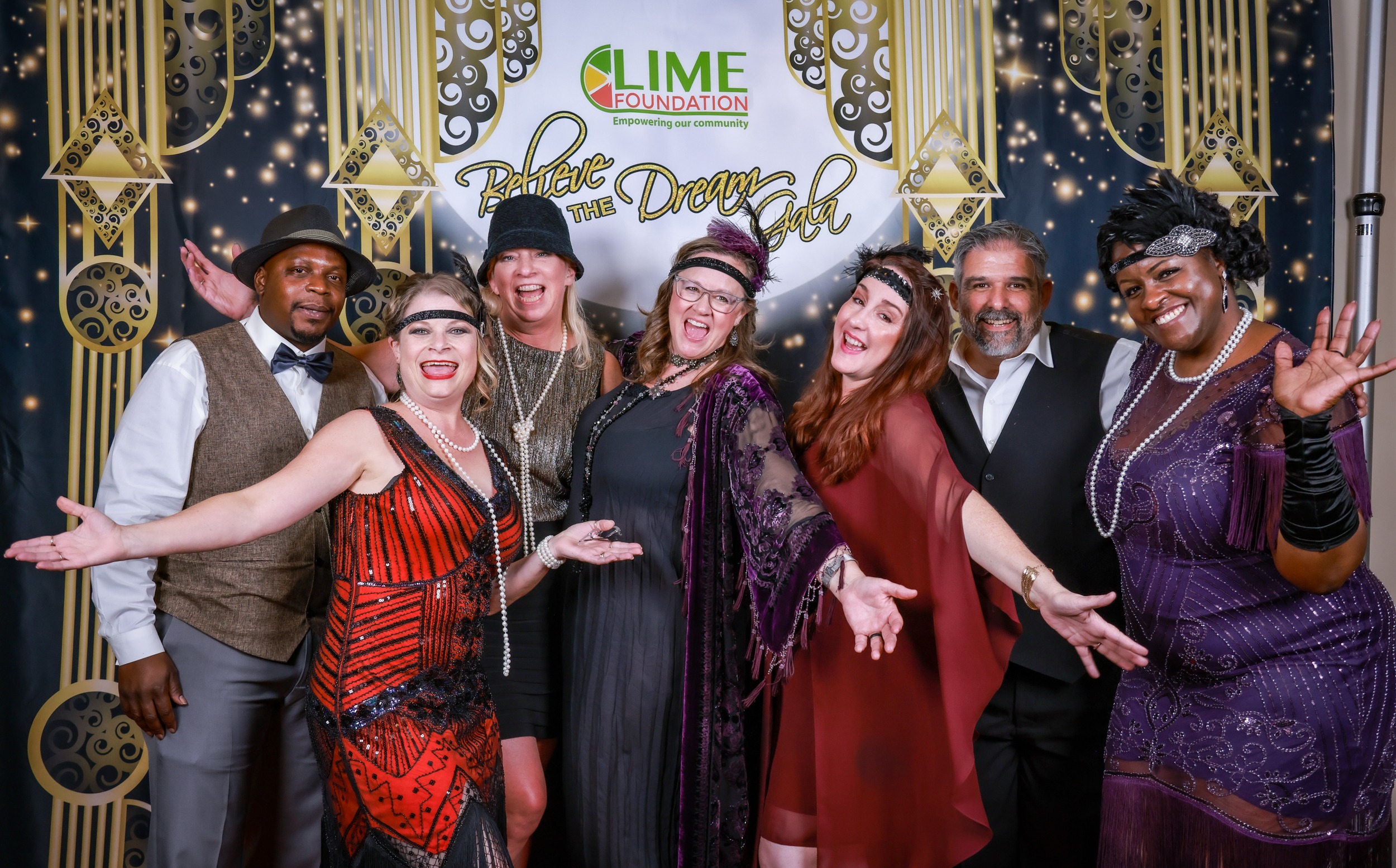 A group of people poses for a photo at a 1920's themed party hosted by a Sonoma County non-profit organization.