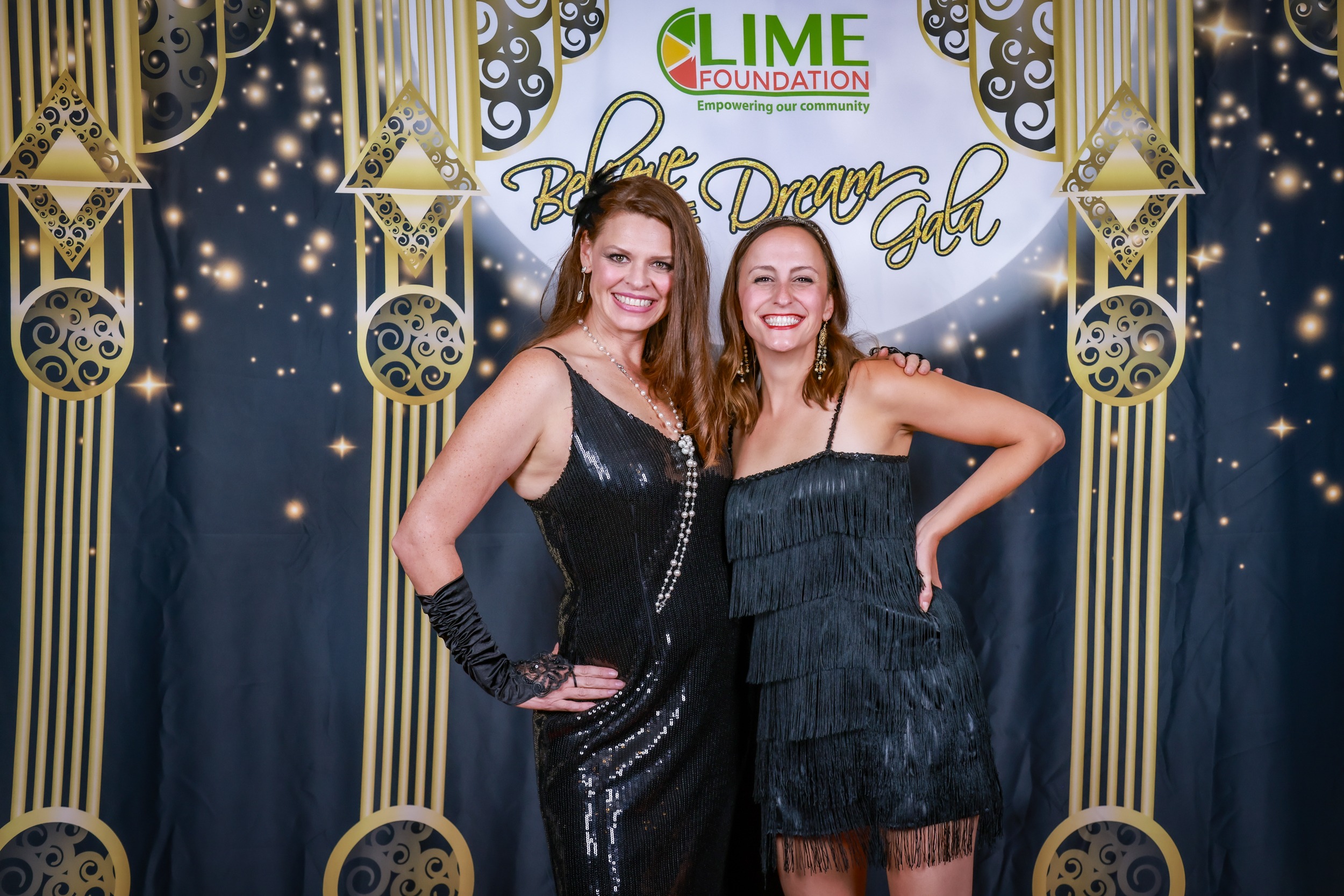 Two women posing for a photo in front of a gilded backdrop at The LIME Foundation of Santa Rosa.