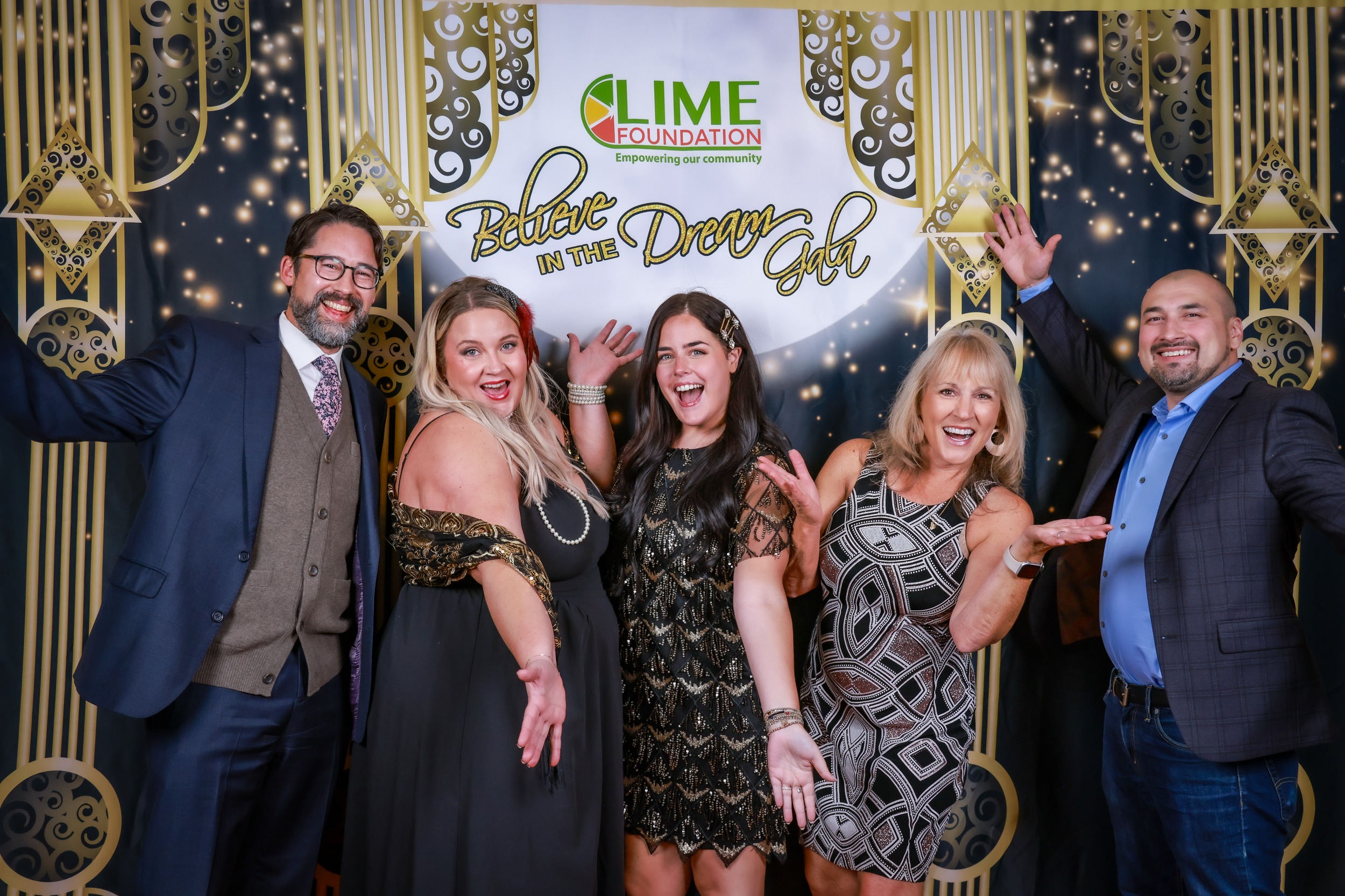 A group of people posing for a photo in front of a gilded backdrop at an event hosted by The LIME Foundation of Santa Rosa.