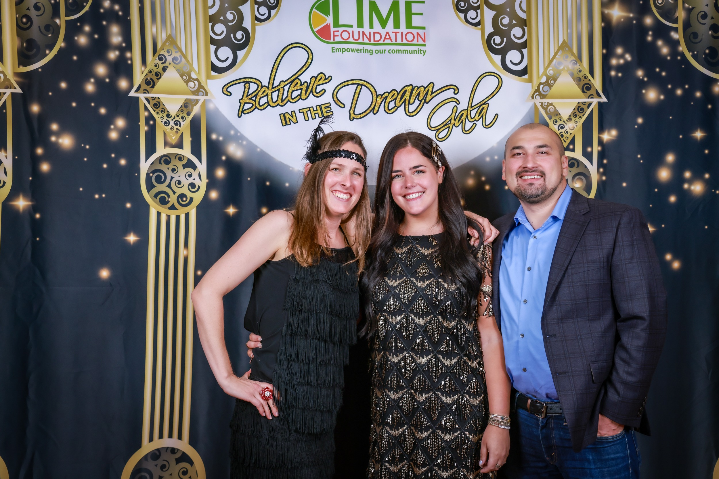 Three individuals posing for a photo in front of a gilded backdrop at The LIME Foundation of Santa Rosa.
