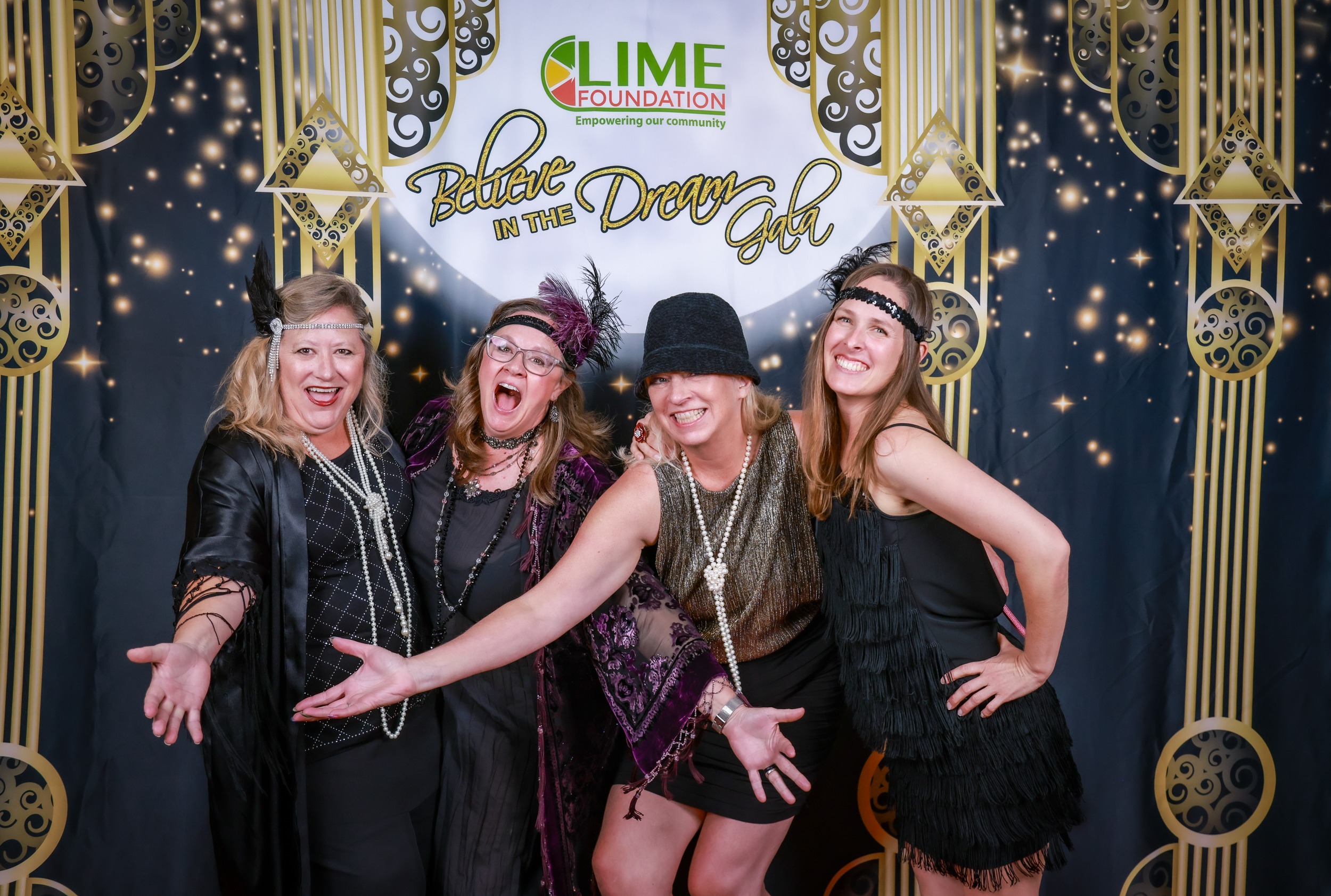A group of women dressed in 1920's attire posing for a photo at a party thrown by The LIME Foundation of Santa Rosa.