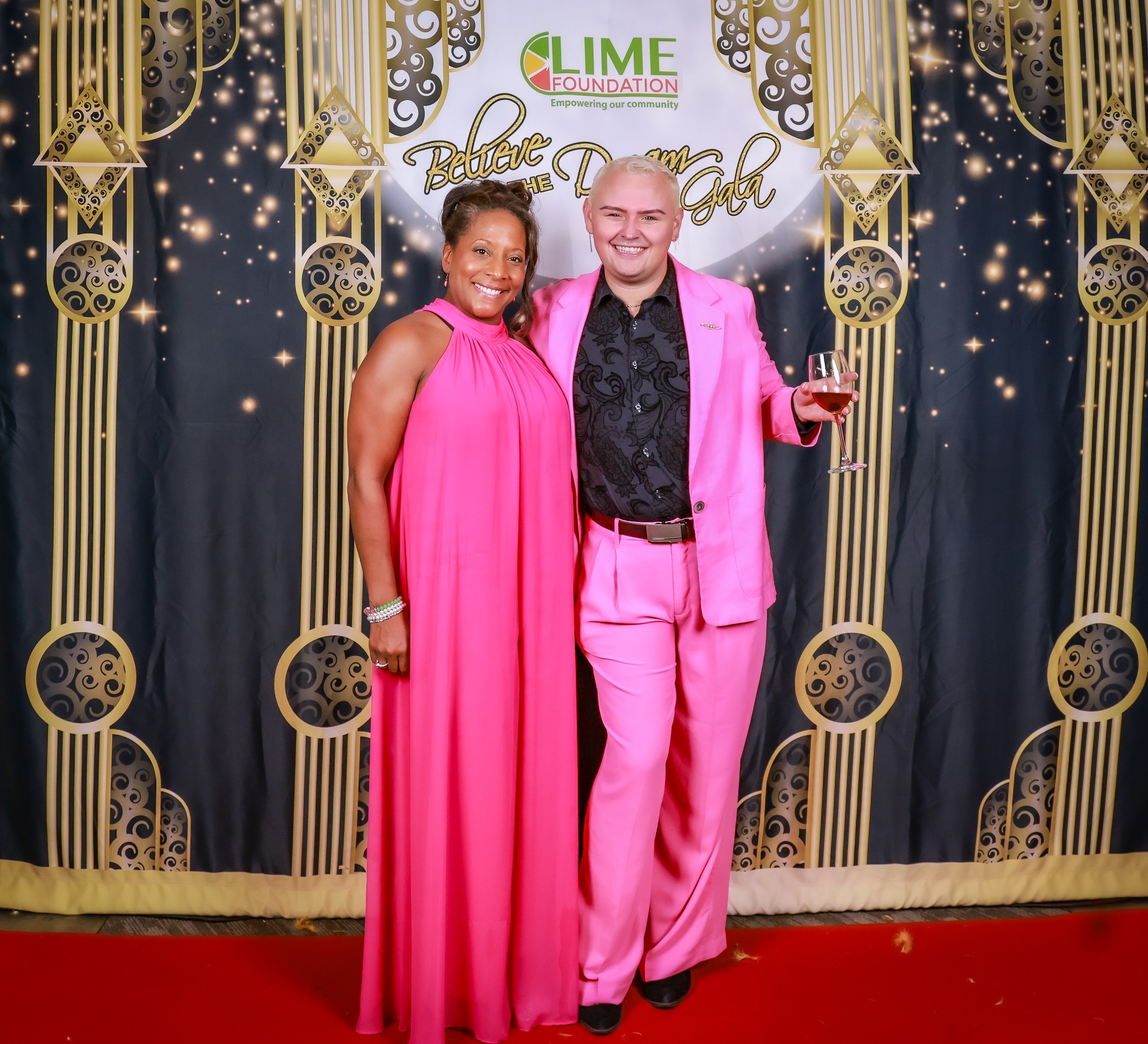 A man in a pink suit stands next to a woman in a pink dress at The LIME Foundation of Santa Rosa.