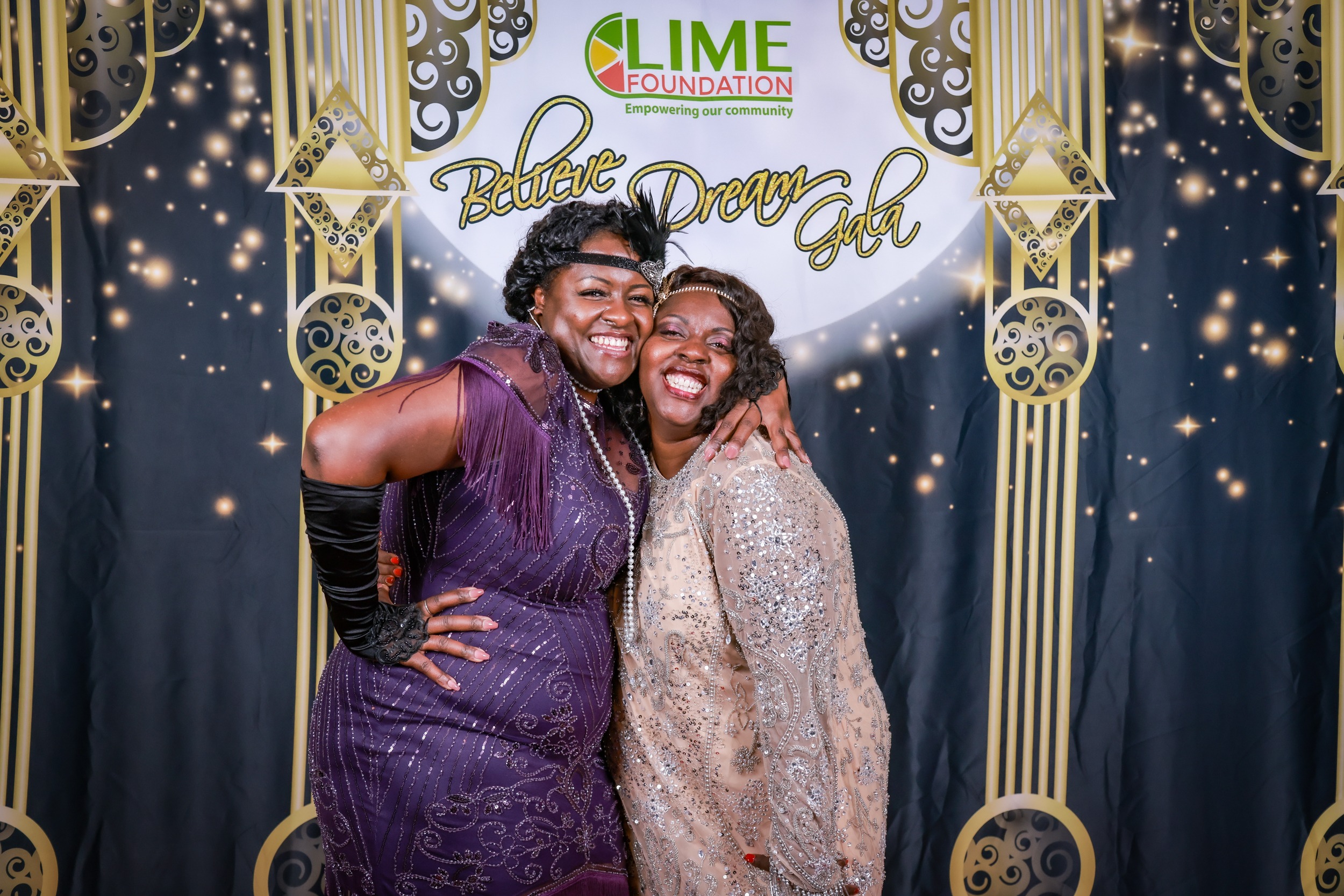 Two women posing for a photo at a 1920's themed party organized by The LIME Foundation of Santa Rosa.