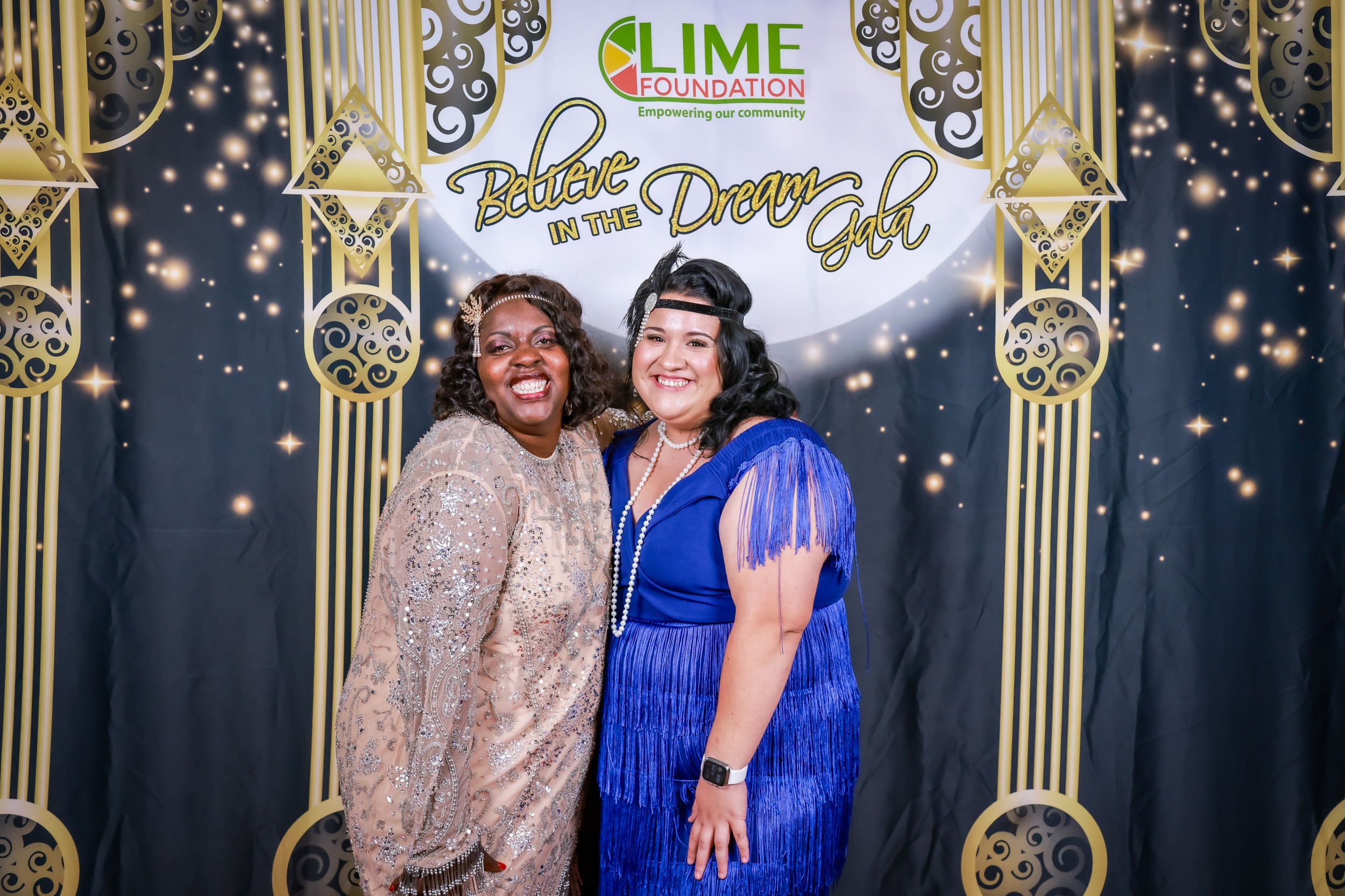 Two women posing for a photo at a 1920's themed party hosted by The LIME Foundation.