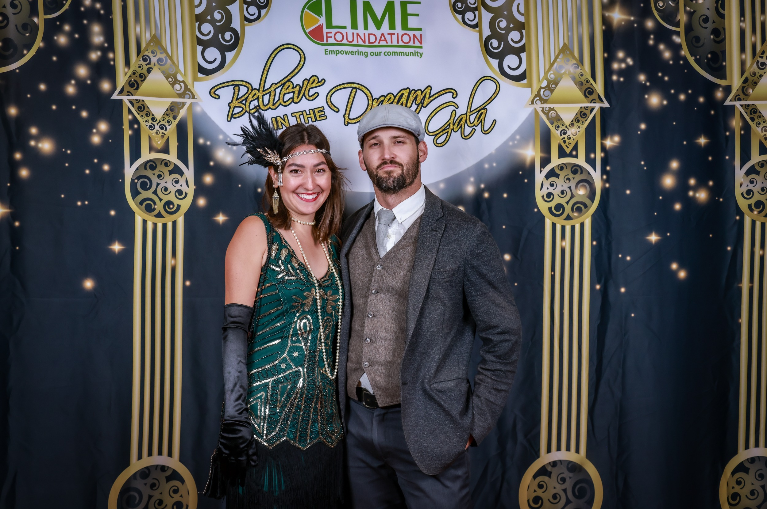 A man and woman posing for a photo at a 1920's themed party hosted by The LIME Foundation in Sonoma County.