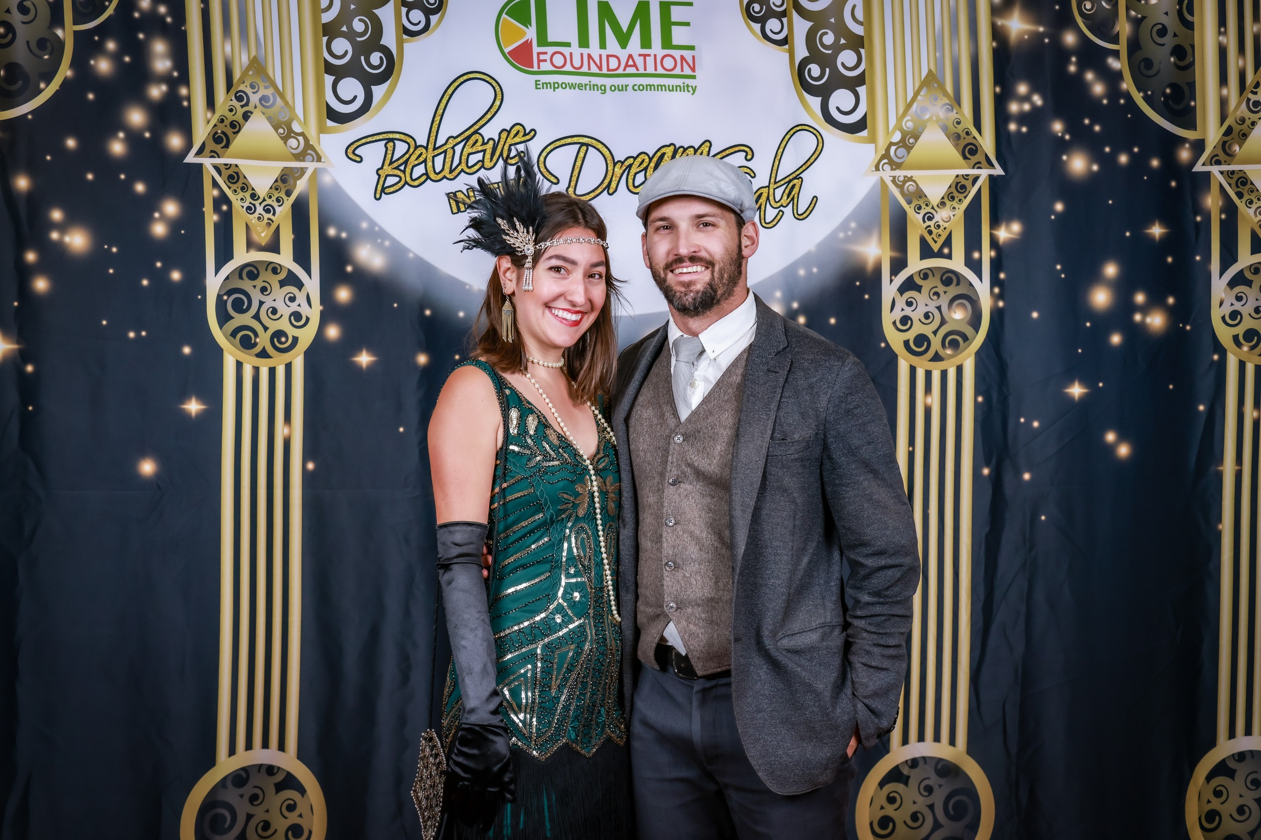 A man and woman pose for a photo at a 1920's themed party hosted by The LIME Foundation of Santa Rosa.