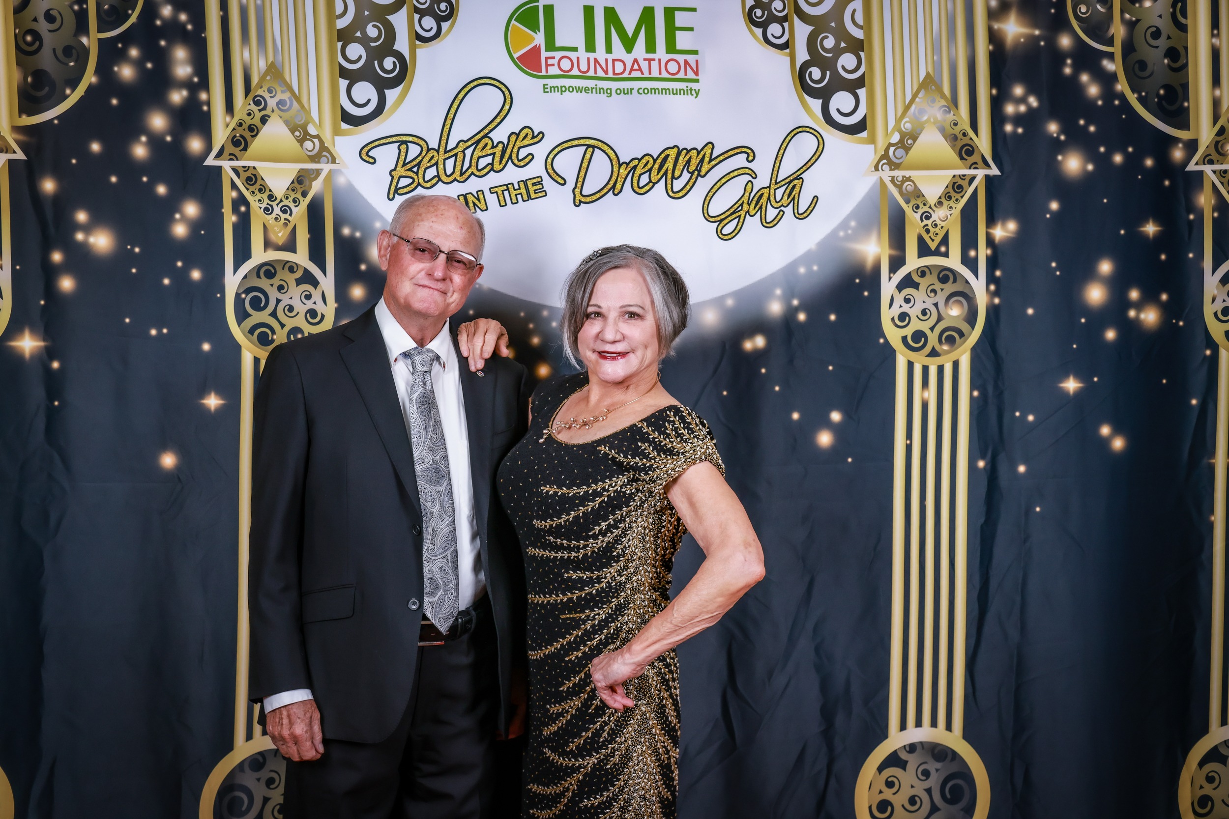 A man and woman posing for a photo in front of a backdrop at The LIME Foundation of Santa Rosa, a non-profit organization.