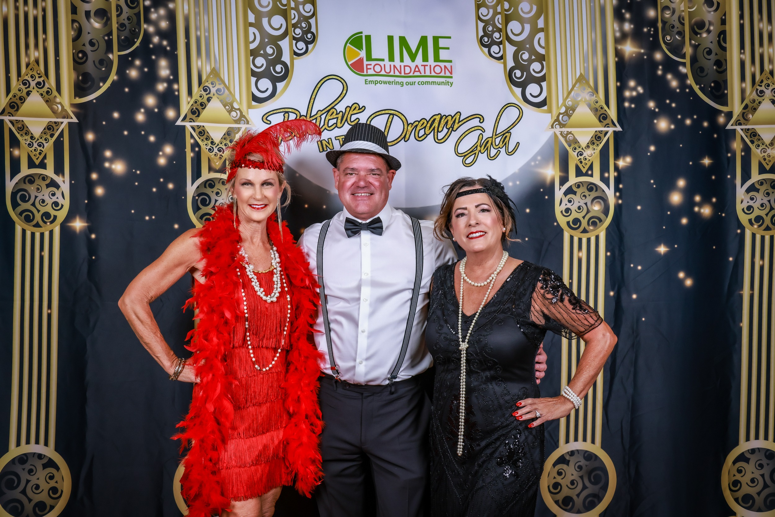 Three people posing for a photo at a Sonoma County non-profit organization's 1920's themed party.