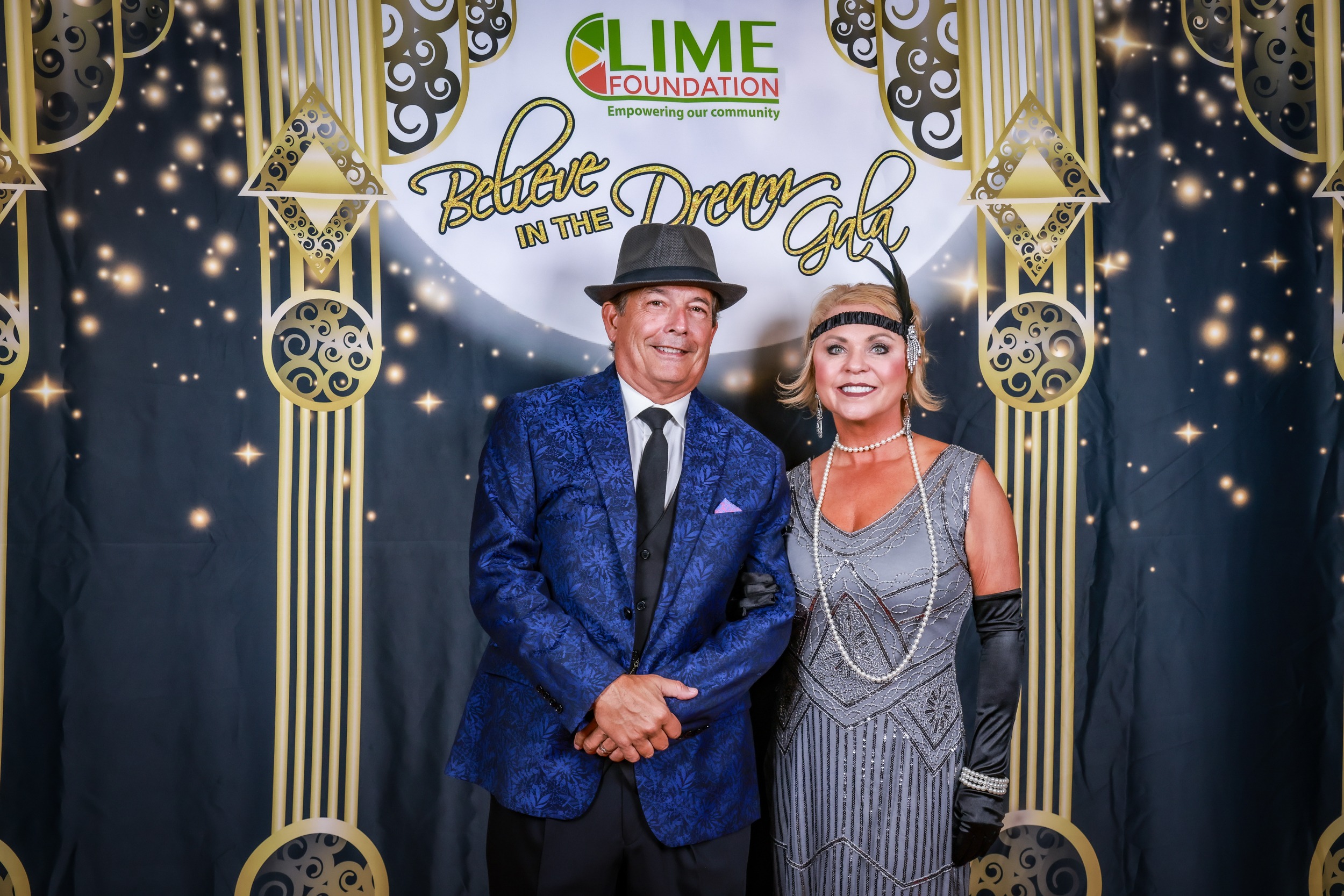 A man and woman pose for a photo at a Gatsby themed party hosted by The LIME Foundation of Santa Rosa.